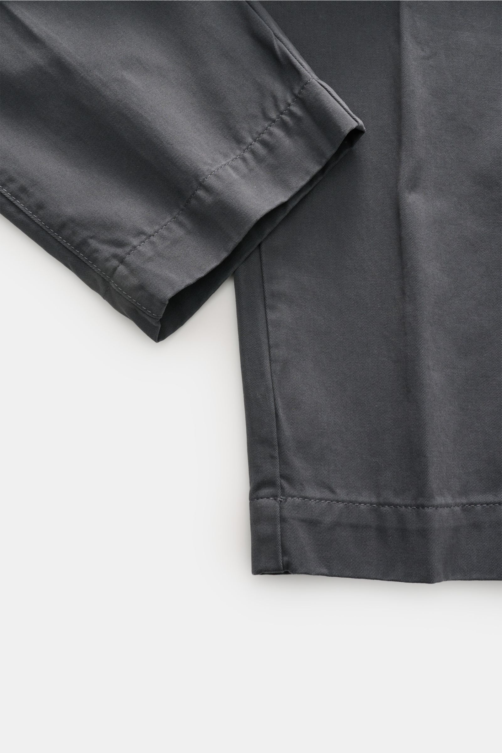 Officine Générale Chinos dark grey shown in close-up from the side, highlighting dense cotton twill fabric, soft feel, tapered ankle length with double pleat and neat stitching. Parisian nonchalance at its most stylish: OFFICINE GÉNÉRALE is synonymous wit
