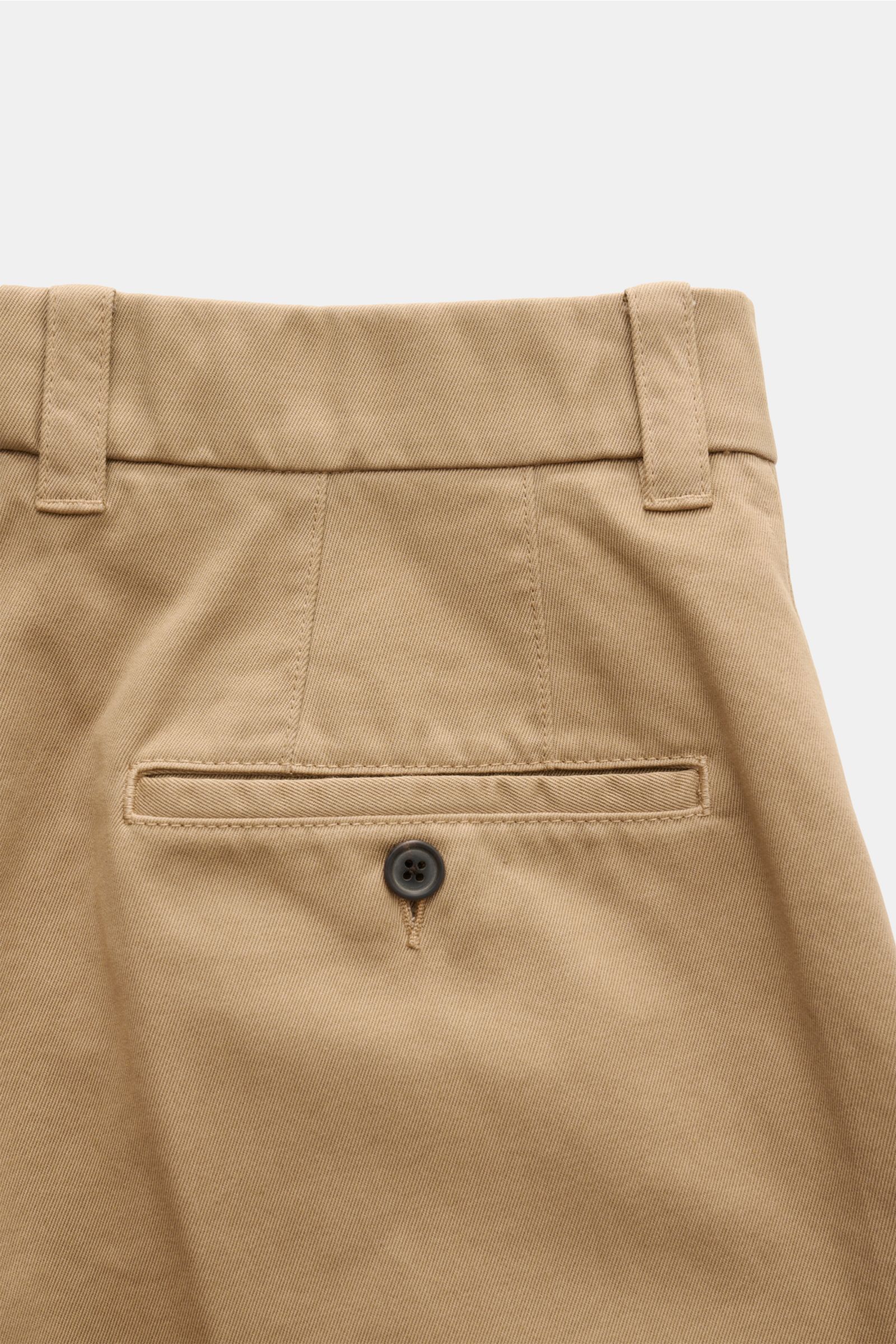 Nahaufnahme der Rückseite einer Thom Browne Chino hellbraun aus schwerem Baumwoll-Twill mit paspelierter Gesäßtasche und Knopf, fotografiert von schräg oben.