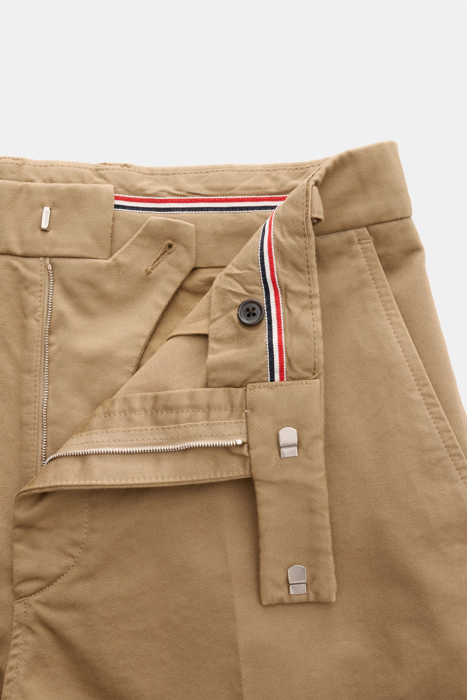 Thom Browne Chino hellbraun aus festem Baumwoll-Twill, Tapered Fit, knöchellang, mit Reißverschluss, Bundhaken und französischen Taschen, Nahaufnahme von oben.