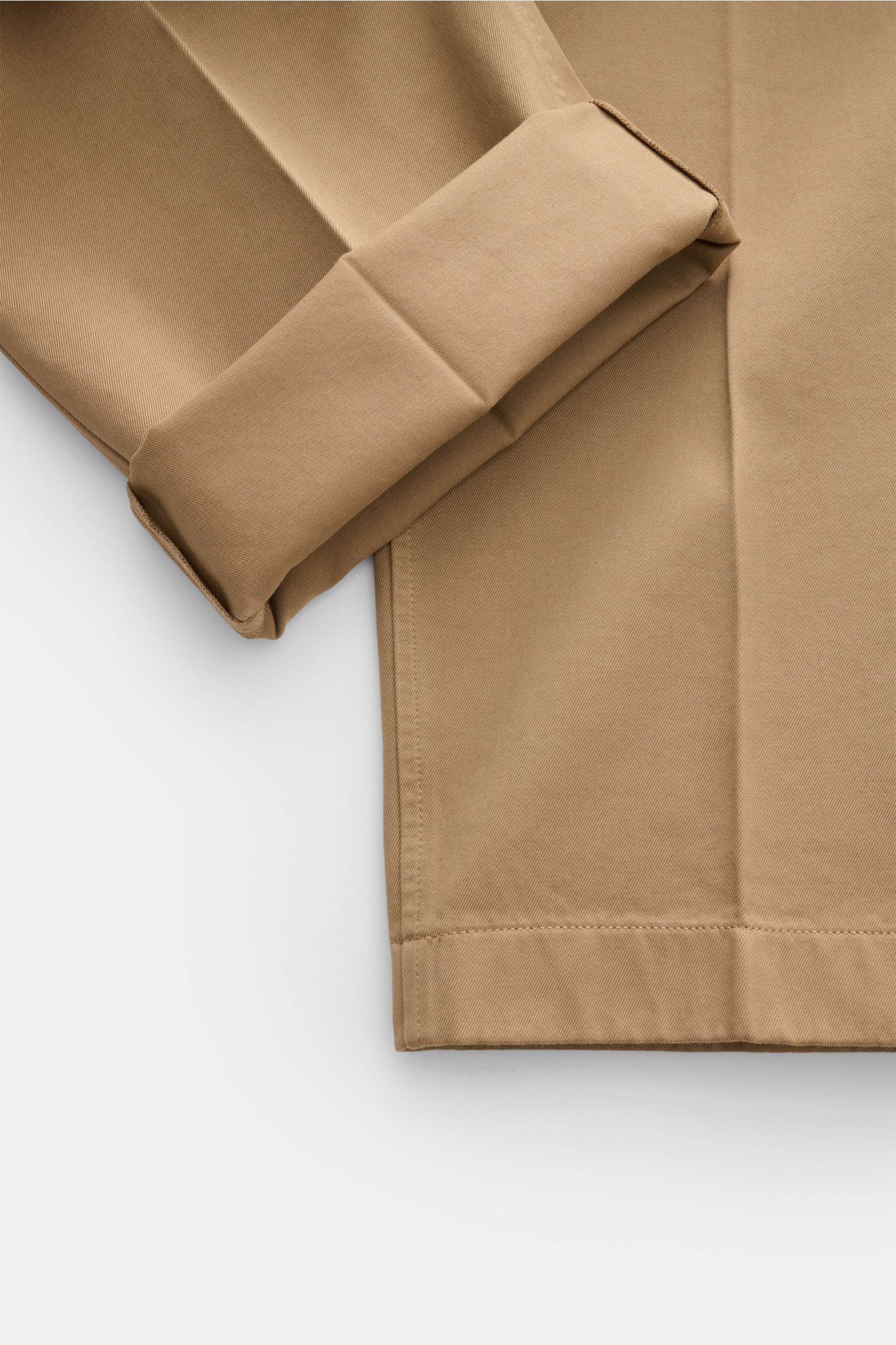 Detailaufnahme einer Thom Browne Chino hellbraun aus festem Baumwoll-Twill mit umgeschlagenem Bein, Tapered Fit und geradem Schnitt.