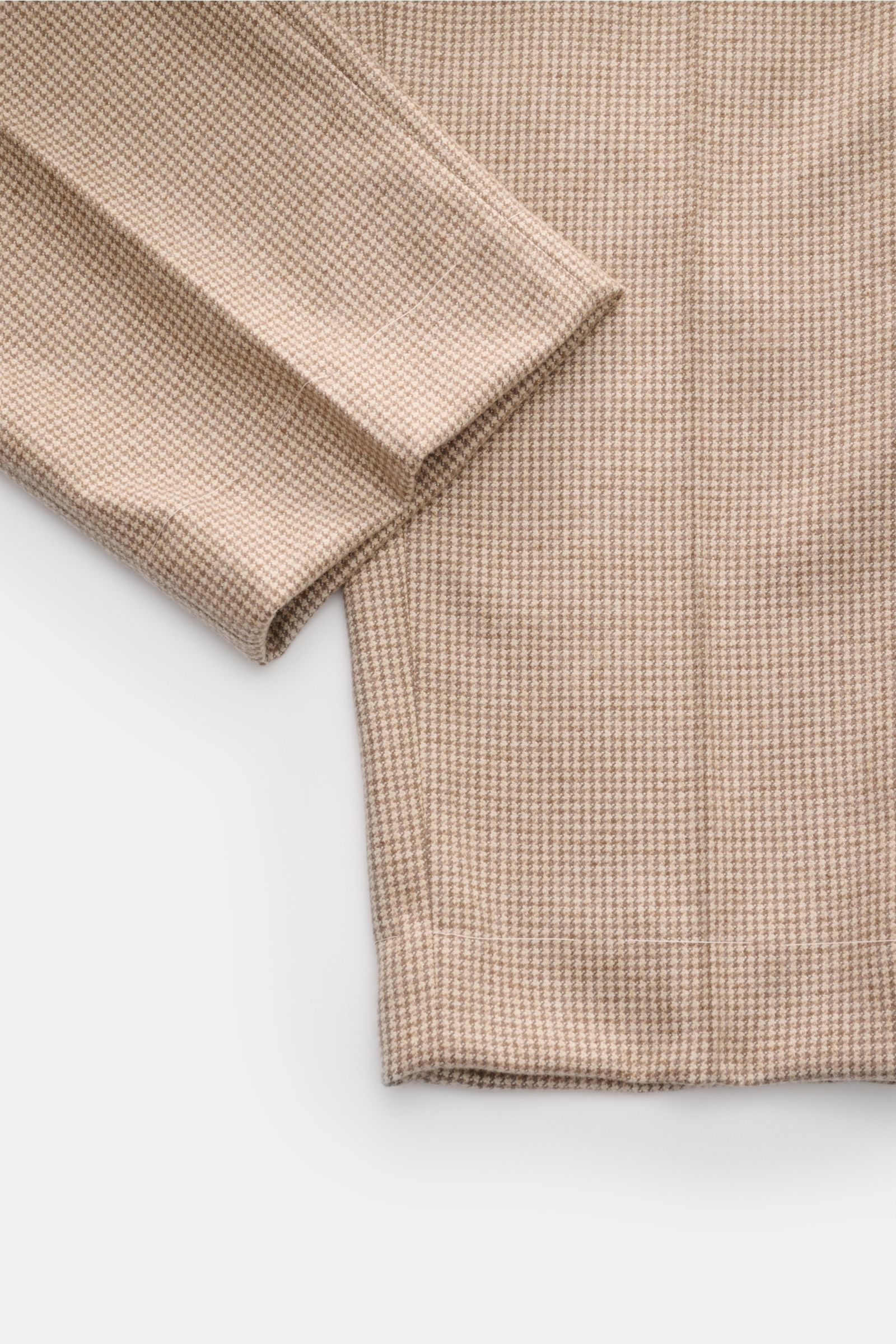 Close-up top-down view of Brunello Cucinelli Hose beige/hellbraun/taupe kariert with fine houndstooth pattern, showcasing soft cashmere-silk fabric, cuff, and subtle crease. Eleganz mit jedem Schritt: Die edle Hose aus einer Cashmere-Seidenmischung von