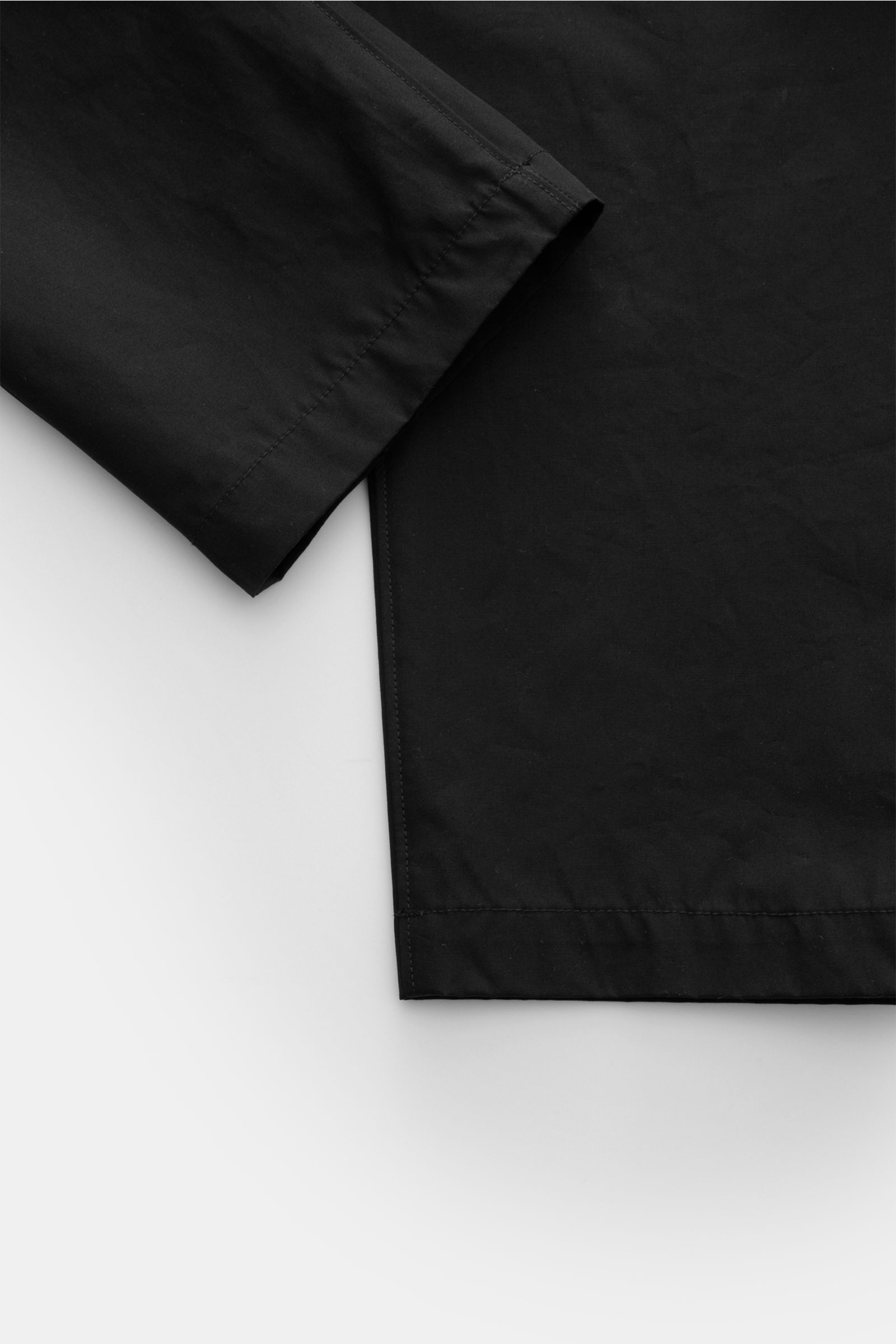 Stone Island Cargohose 'Ghost Piece' schwarz, knöchellang, aus Baumwoll-Twill, Frontansicht mit Bund, Taschen und tonalem Kompass-Badge.