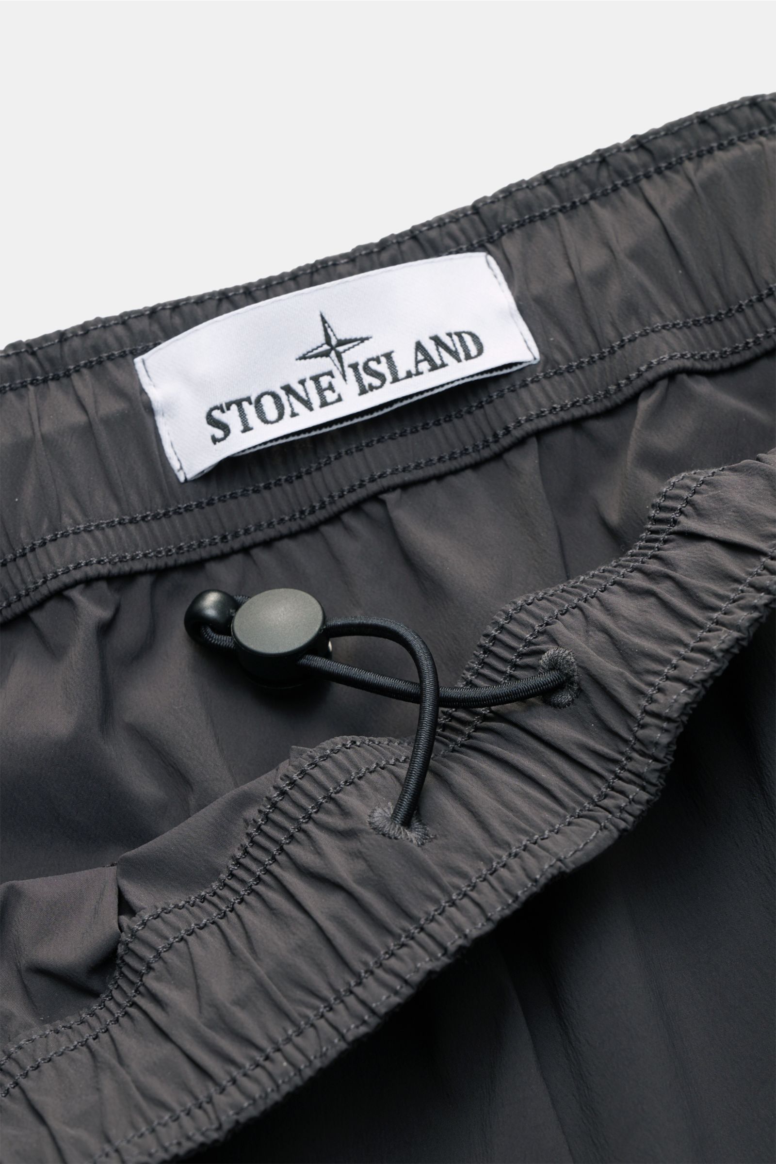 Stone Island Hose 'Stellina' dunkelgrau, Nahaufnahme elastischer Bund mit Tunnelzug, leichtes Microfaser-Gewebe, urban-casual Style, Stern-Stitching.