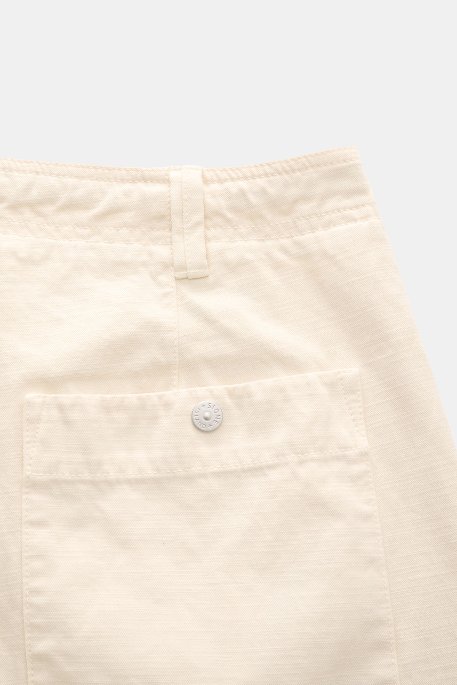 Stone Island Cargohose 'Marina' creme shown from a close-up rear perspective, highlighting the back pocket with button closure. Maritime Utility-Ästhetik: Die Cargohose aus der 'Marina'-Kollektion von STONE ISLAND vereint funktionale Details mit lässiger 
