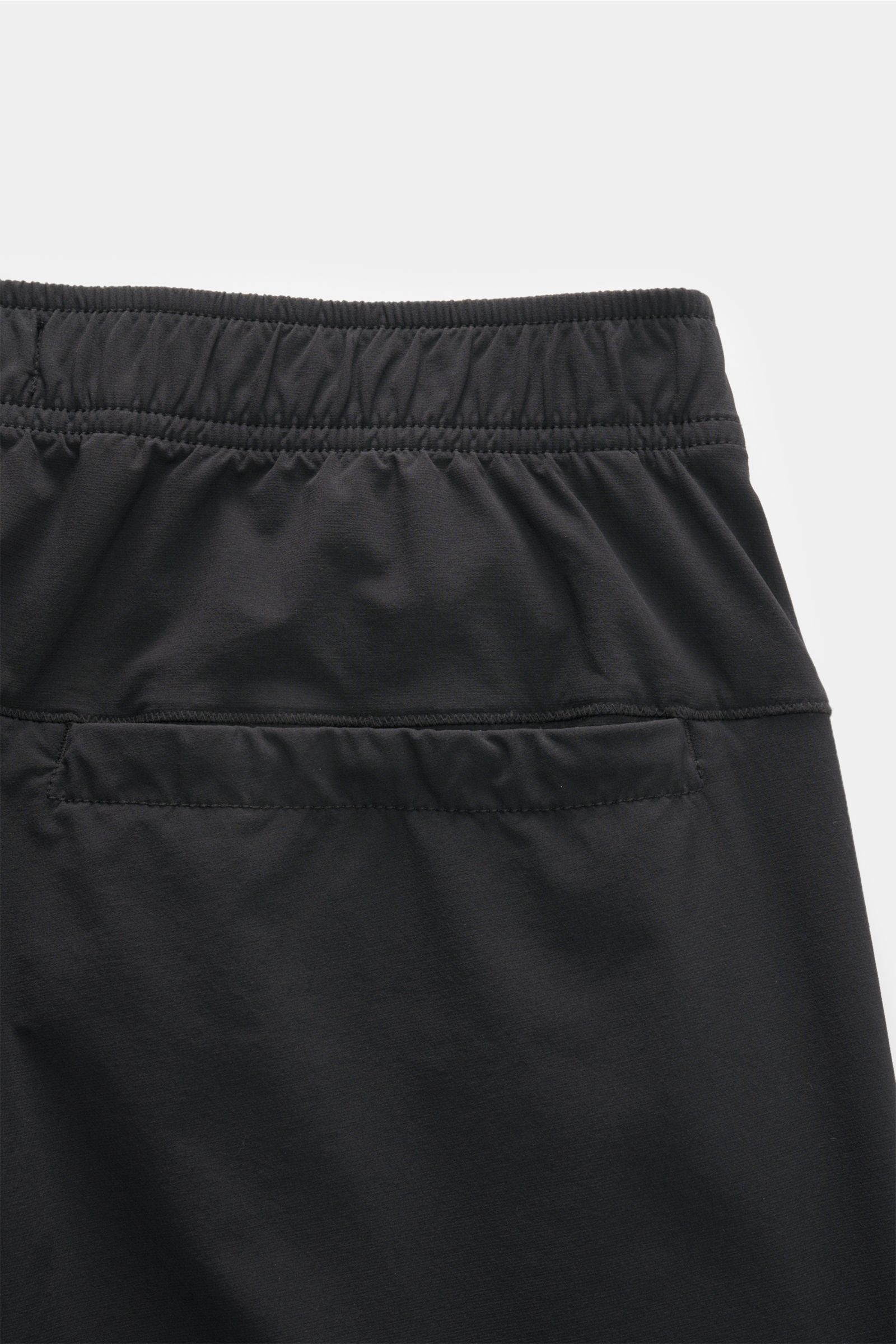 Close-up rear view of Stone Island Jogger pants black showing elasticated waistband and back pocket, made of high-quality microfibre. Create casual looks for the spring season: These jogger pants by STONE ISLAND are synonymous with sporty and relaxed casu