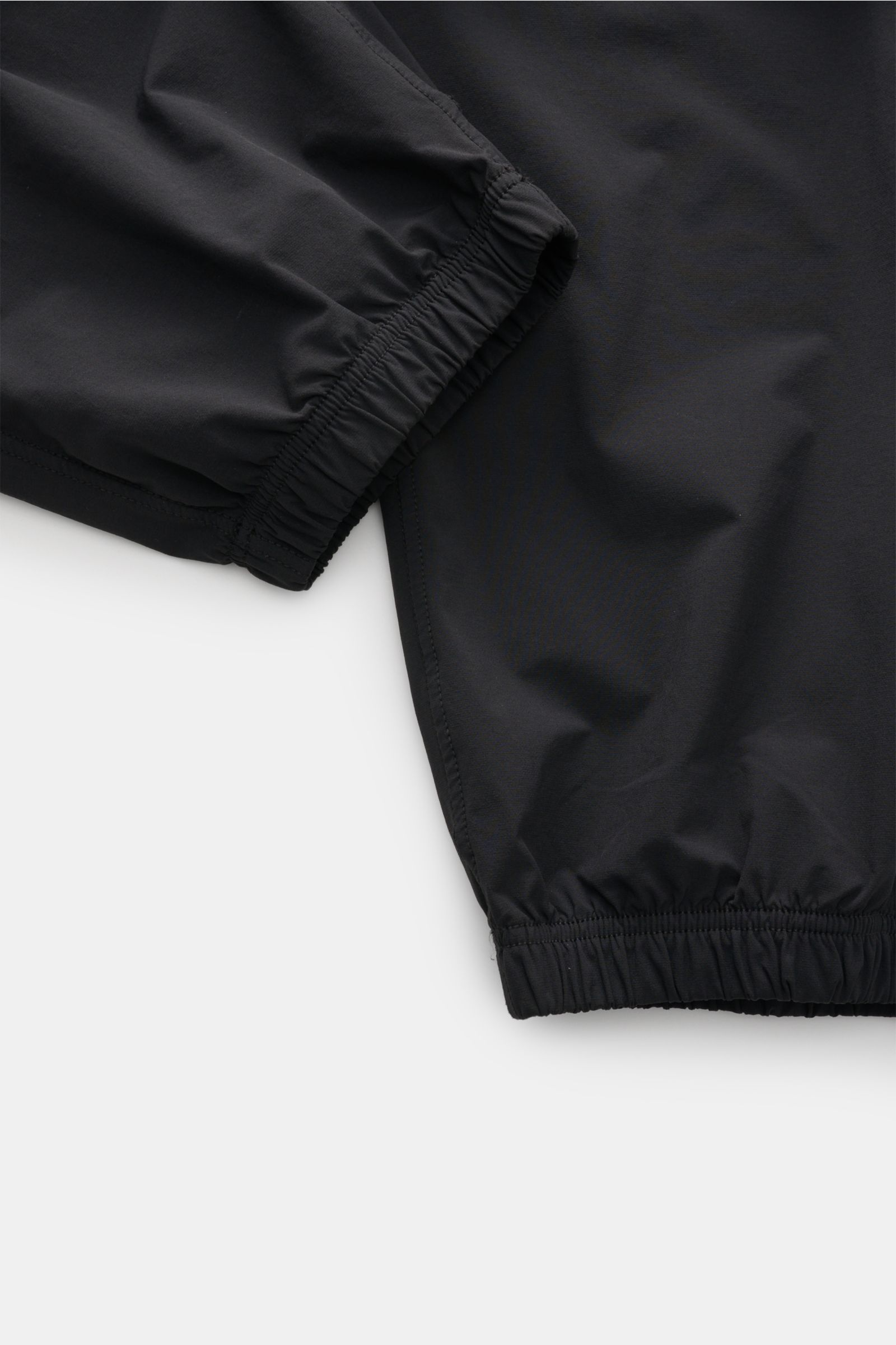 Close-up image of Stone Island Jogger pants black showing elasticated cuffs and slightly tapered cut from a top-down perspective, highlighting high-quality microfibre and sporty casual design. 

Create casual looks for the spring season: These jogger p