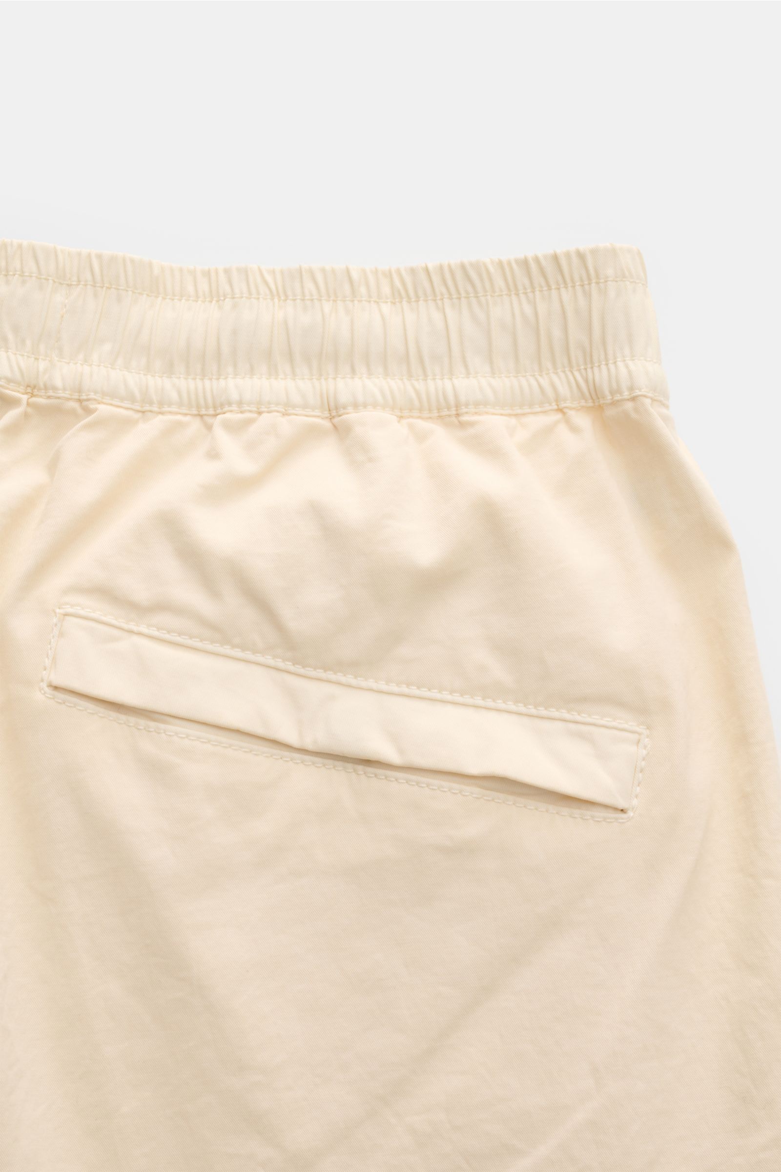 Stone Island Cargo-Jogpants 'Regular Tapered' creme, Detailaufnahme der Gesäßtasche mit Druckknopf, elastischem Bund und Bio-Baumwolle.