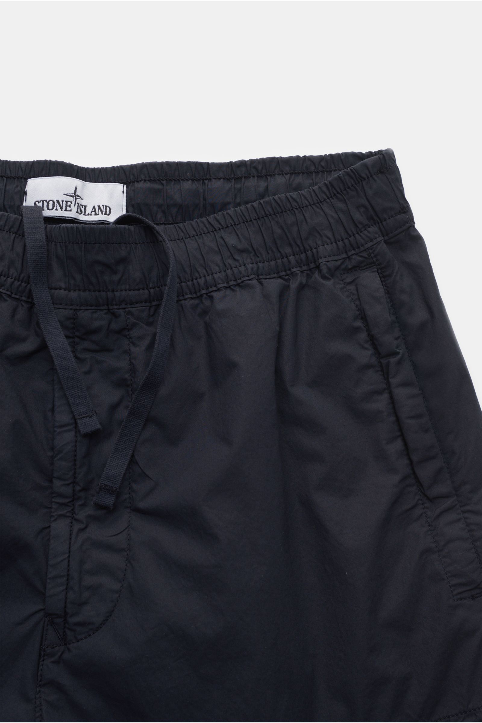 Nahaufnahme der Stone Island Cargo-Jogpants 'Regular Tapered' navy von vorne, elastische Baumwolle, Tunnelzugbund, Reißverschlusstaschen, Cargo-Taschen, Kompass-Badge.