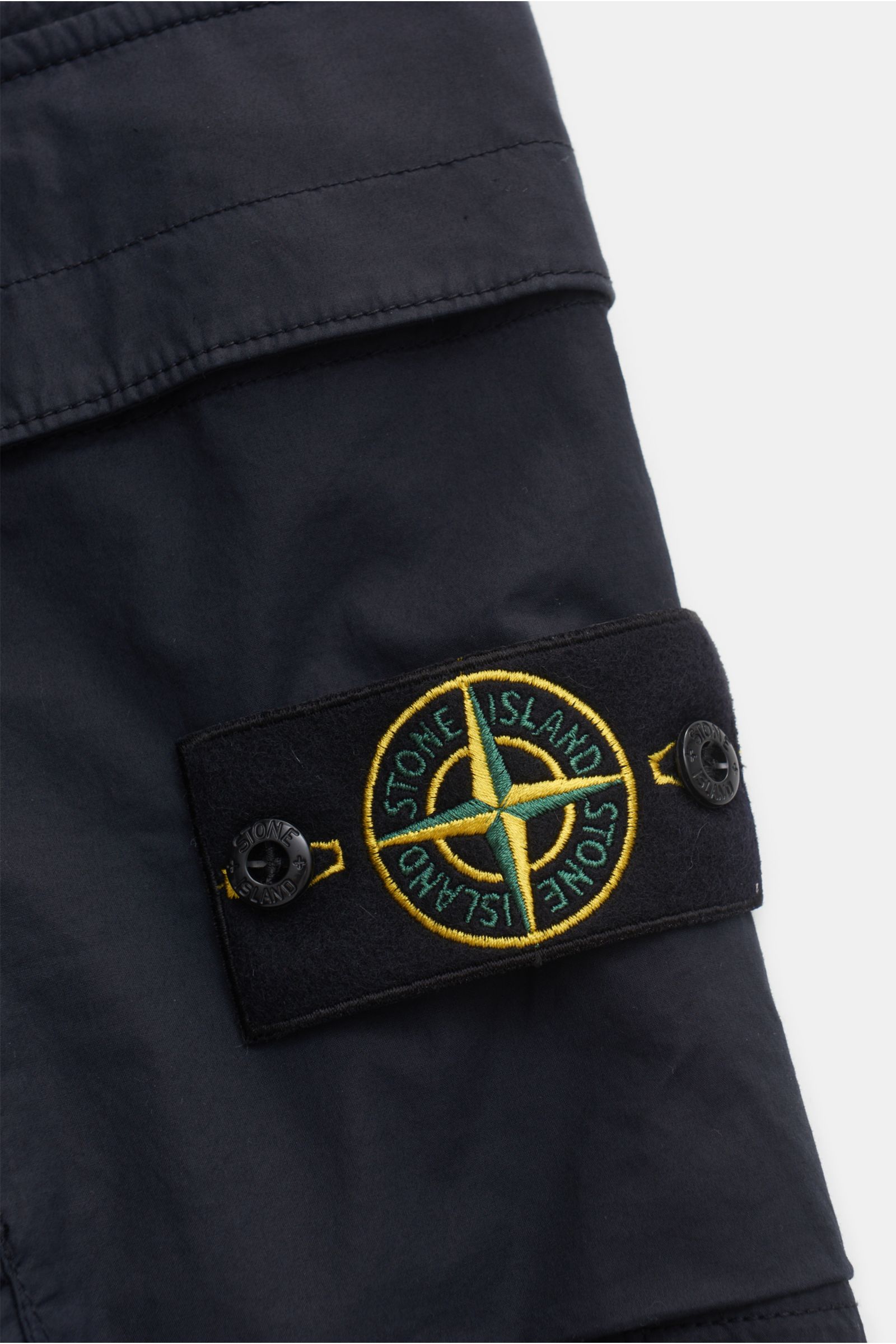 Stone Island Cargo-Jogpants 'Regular Tapered' navy, Detailaufnahme von klassischem Kompass-Badge auf Cargo-Tasche, Baumwolle mit Stretch.