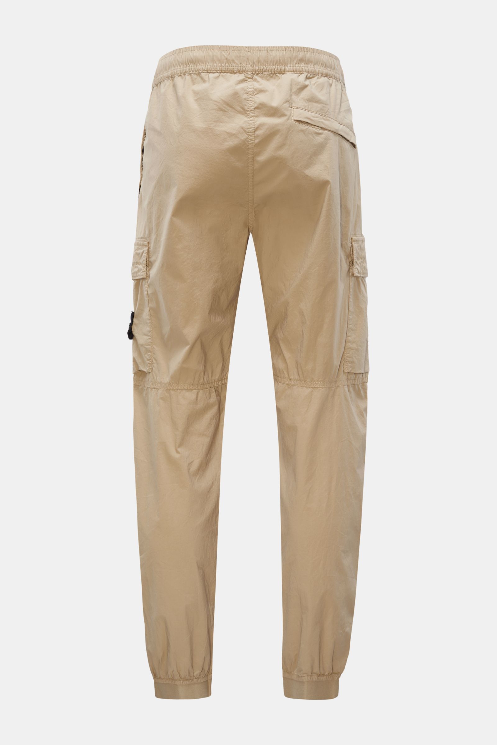 Stone Island Cargo-Jogpants 'Regular Tapered' beige shown from the back, elastic cotton with soft feel, elastic waistband, side seam and cargo pockets, knee darts, elastic cuffs, and signature compass badge. For those who want function and style – these j