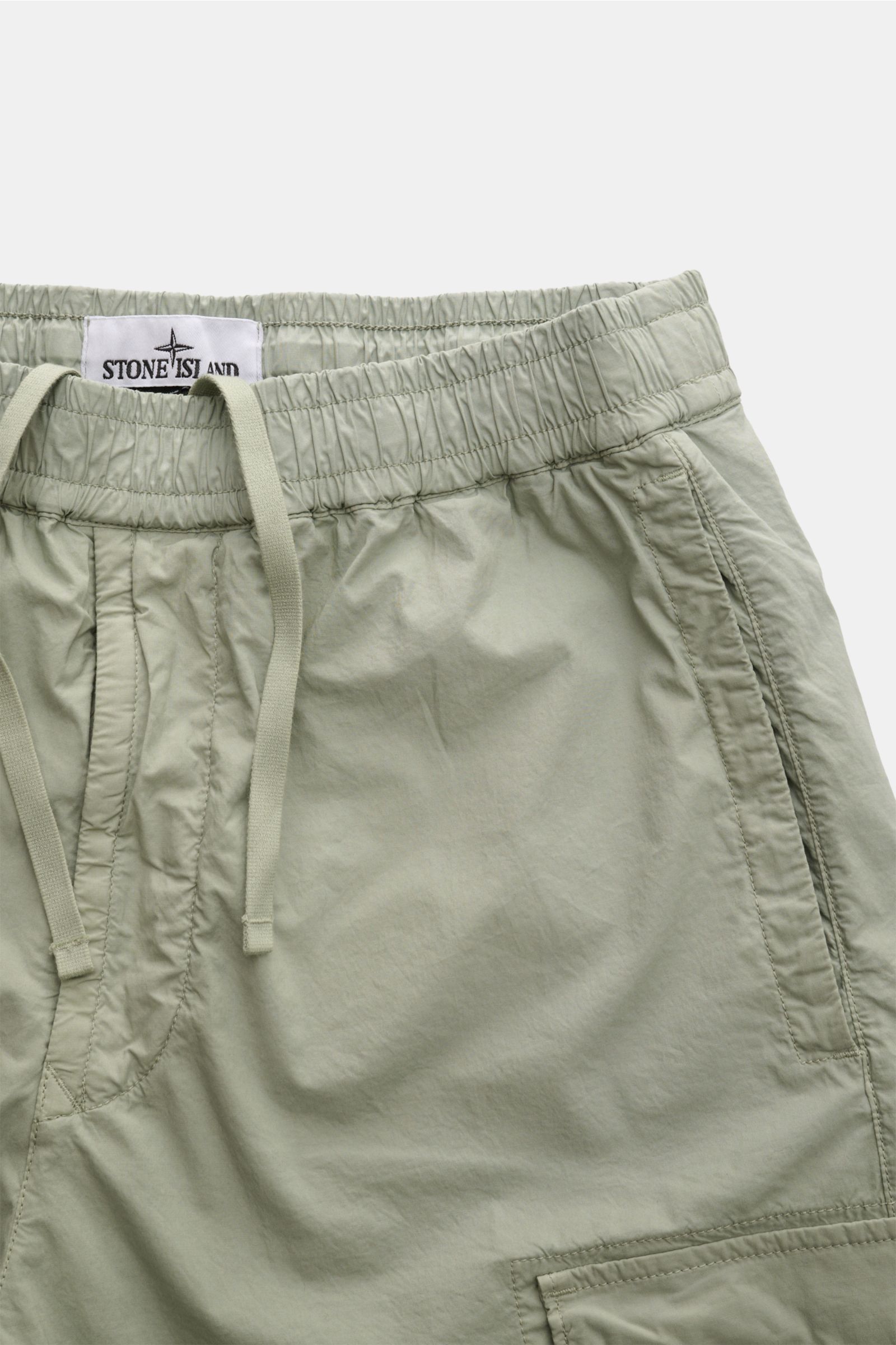 Stone Island Cargo-Jogpants 'Regular Tapered' salbei, elastische Baumwolle, Tunnelzug, Reißverschlusstasche, Cargo-Taschen, weicher Griff, nah oben fotografiert.
