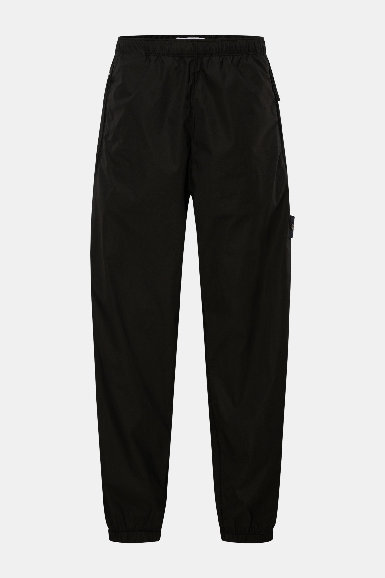 Stone Island Jogpants schwarz, frontal fotografiert, aus elastischer Baumwolle mit Rippstrick-Einsatz, Zipper-Taschen, elastischem Bund und Beinabschlüssen.
