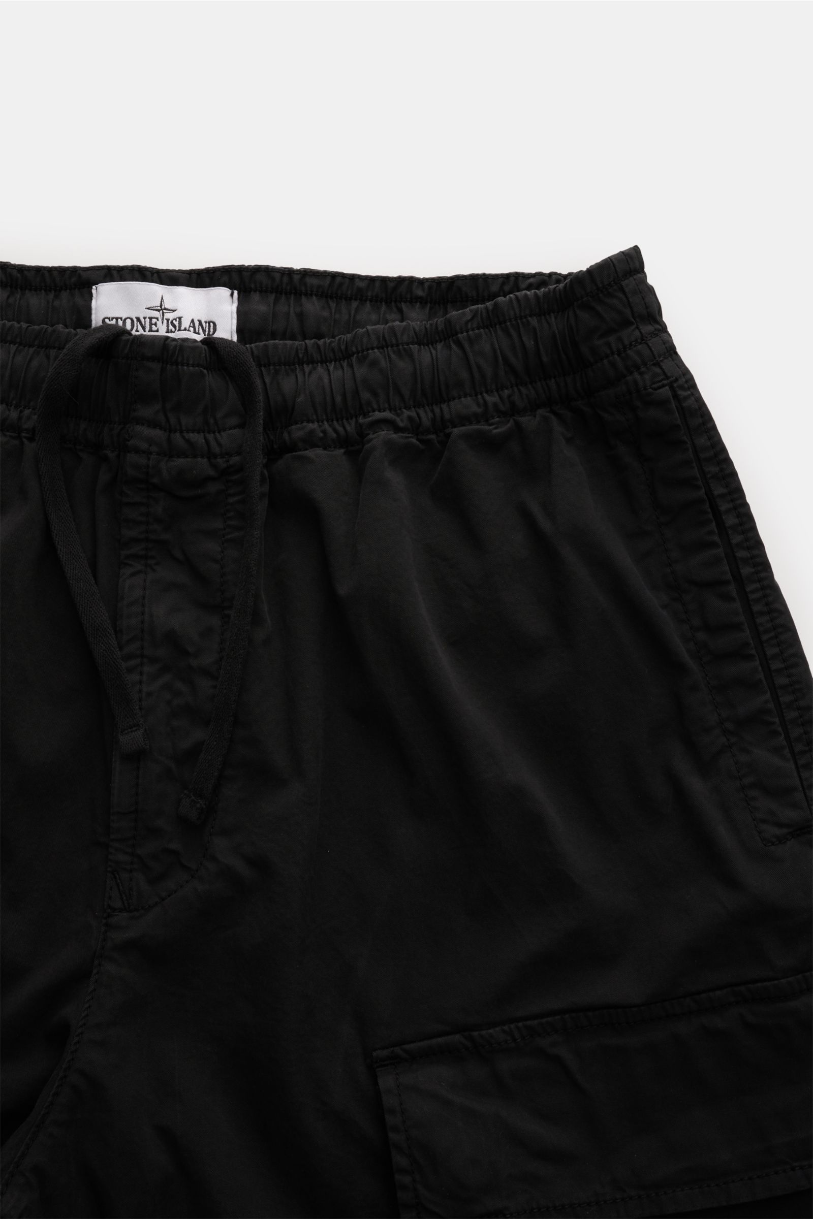 Stone Island Cargo-Jogpants schwarz aus leicht elastischer Baumwolle, Regular Fit, elastischer Bund, aufgesetzte Taschen, Kompass-Badge, Nahaufnahme von oben.