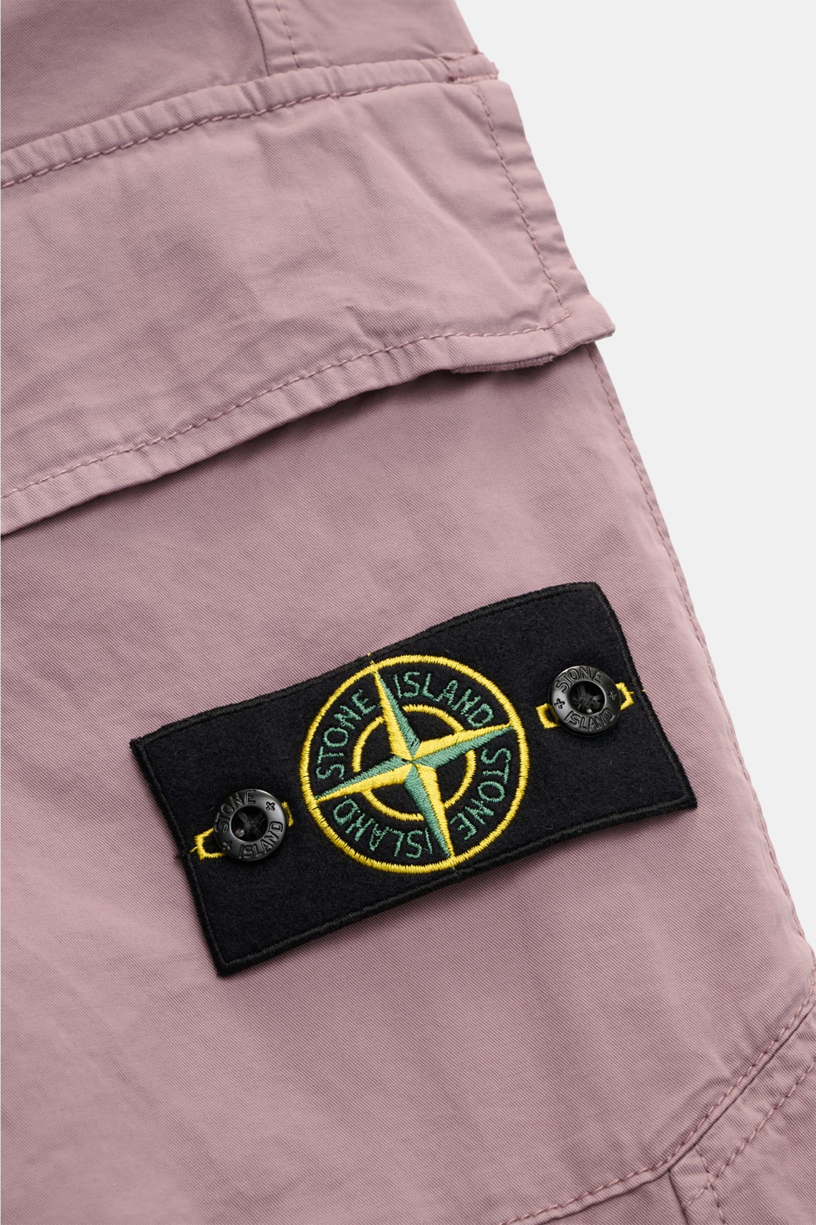 Close-up detail of the Stone Island Cargo-Jogpants violett showing the black compass badge on the side pocket, photographed from above.

Description: Diese leger geschnittene Jogpants aus hochwertiger, leicht elastischer Baumwolle von STONE ISLAND hat 