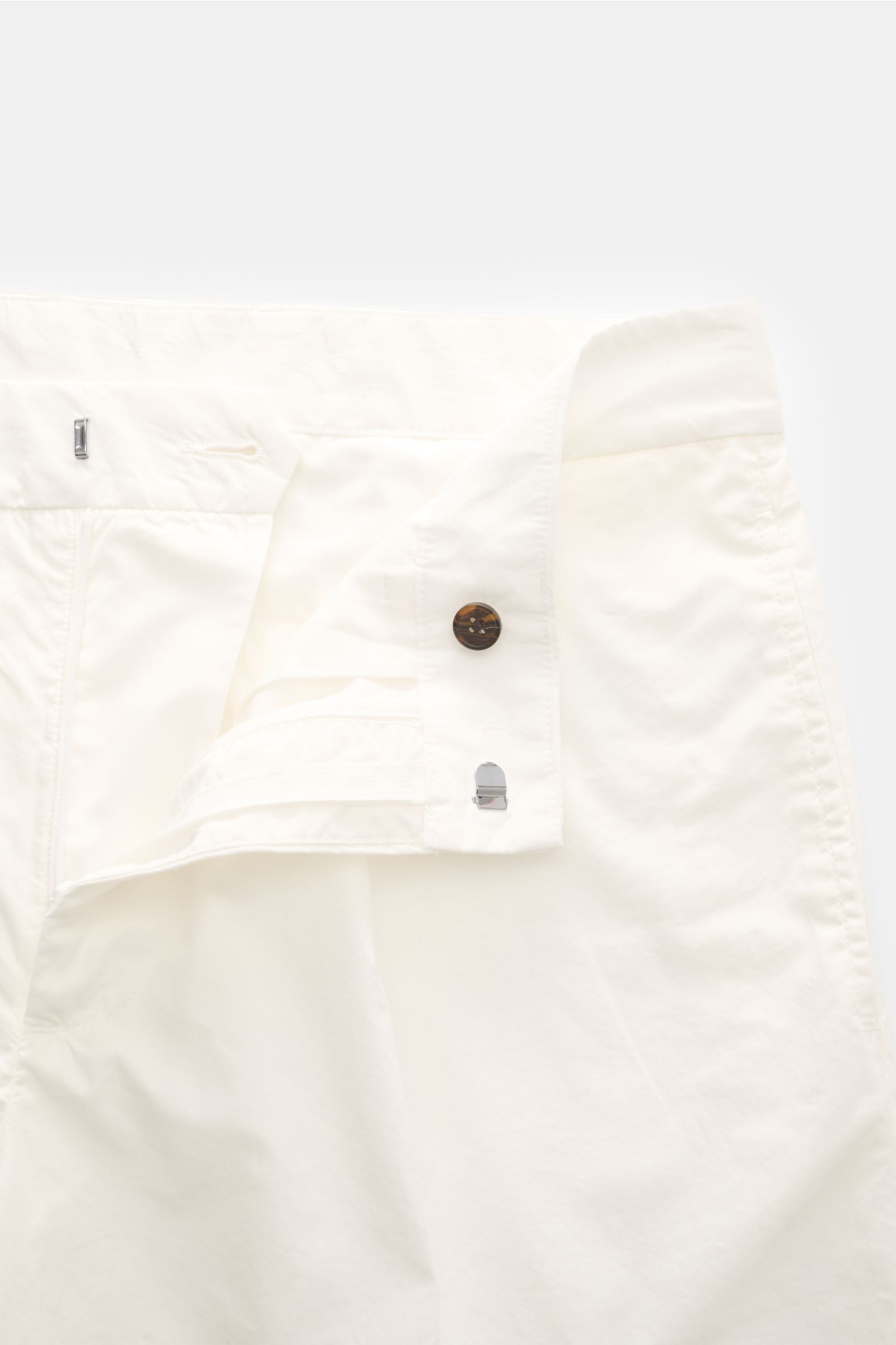 Emporio Armani Baumwollhose offwhite, leichte Baumwolle, Regular Fit, schmal zulaufend, Reißverschluss, Bundhaken, Taschen, Front nah fotografiert.