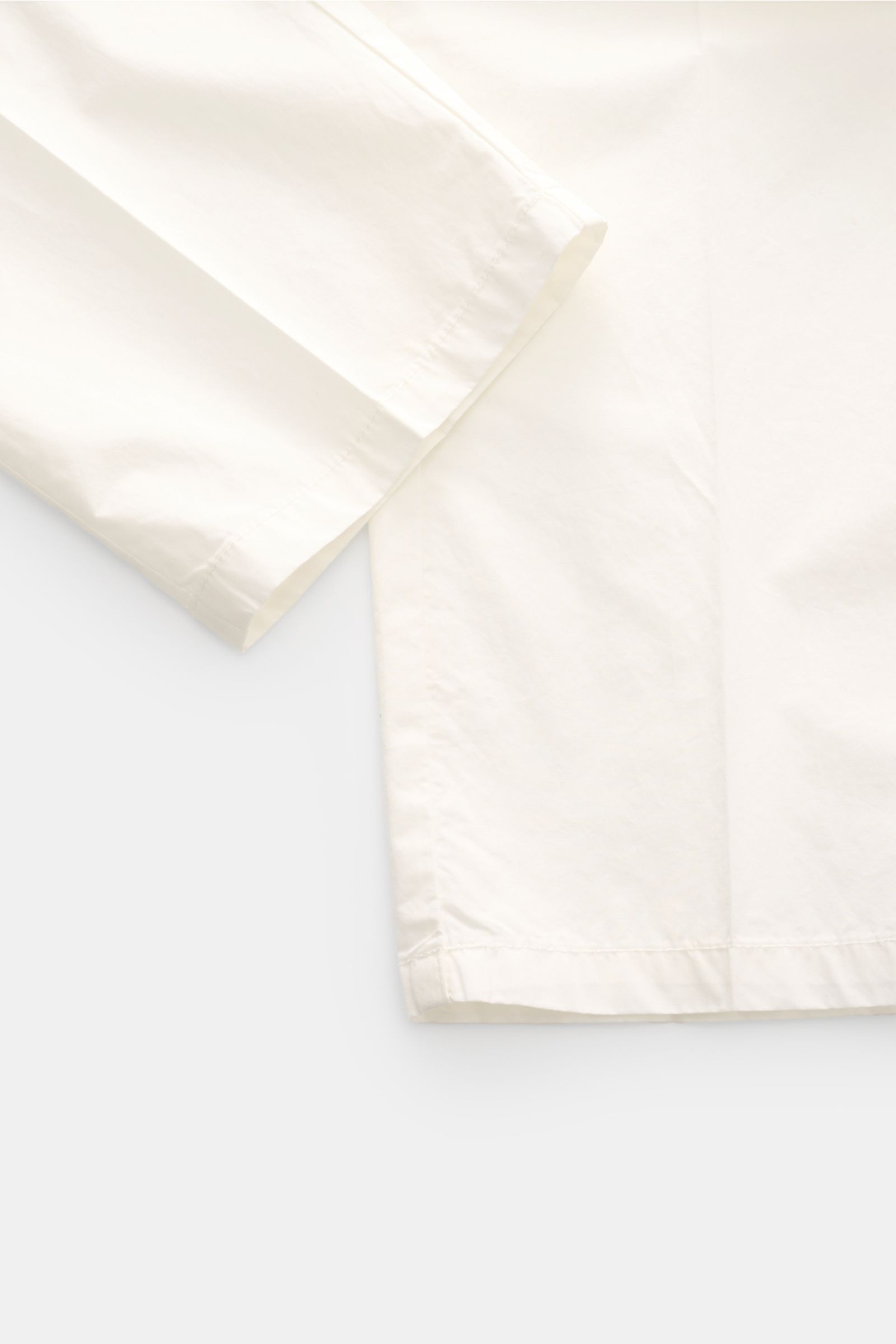 Emporio Armani Baumwollhose offwhite, leichte Baumwollhose mit Regular Fit, schmal zulaufend, Seiten- und paspelierte Gesäßtaschen, Detailfoto von unten.