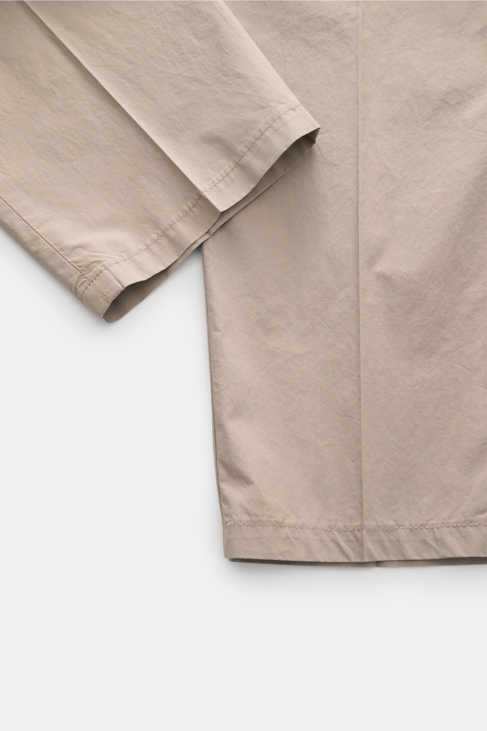 Close-up, top-down view of Emporio Armani Cotton trousers taupe, showing smooth, lightweight pure cotton fabric with regular fit, slightly tapered cut, zip and hook fastener, side seam pockets, and jetted back pockets; summer essential for stylish, breath