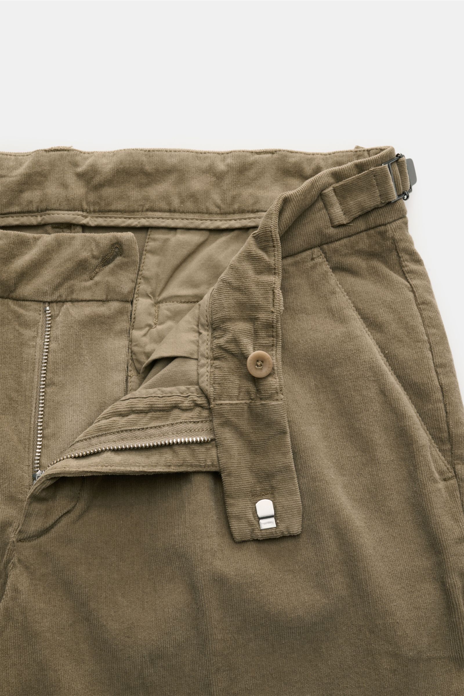 Close-up top view of 04651/ A trip in a bag Corduroy trousers taupe showing zip, button, side adjuster, double pleat, and French pockets.