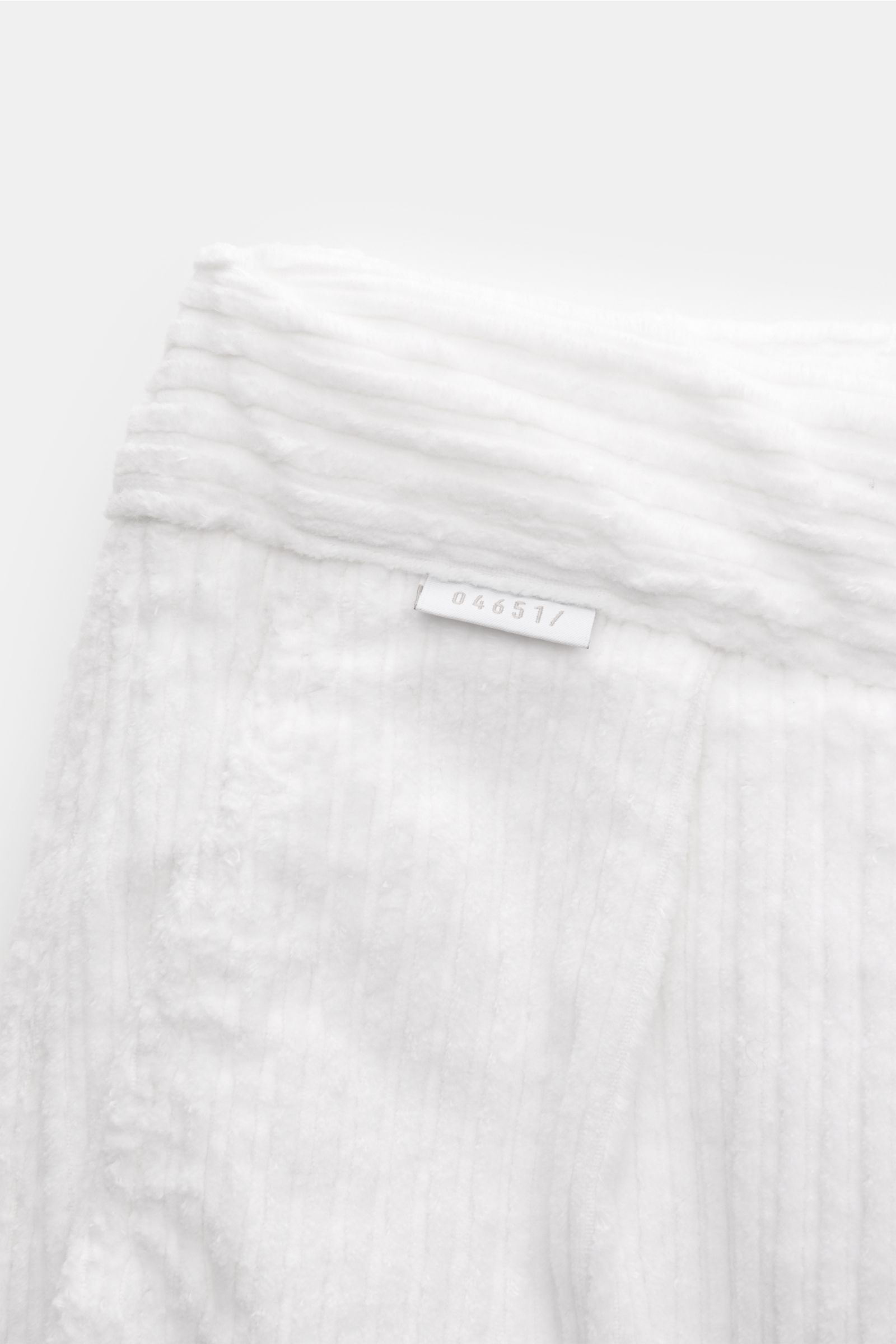 Close-up top-down view of 04651/ A trip in a bag Corduroy cargo pants off-white showing wide wale cotton corduroy, soft feel, tapered fit, regular thigh width, ankle length, zip and waist button, partially elasticated waistband with drawstring, French poc