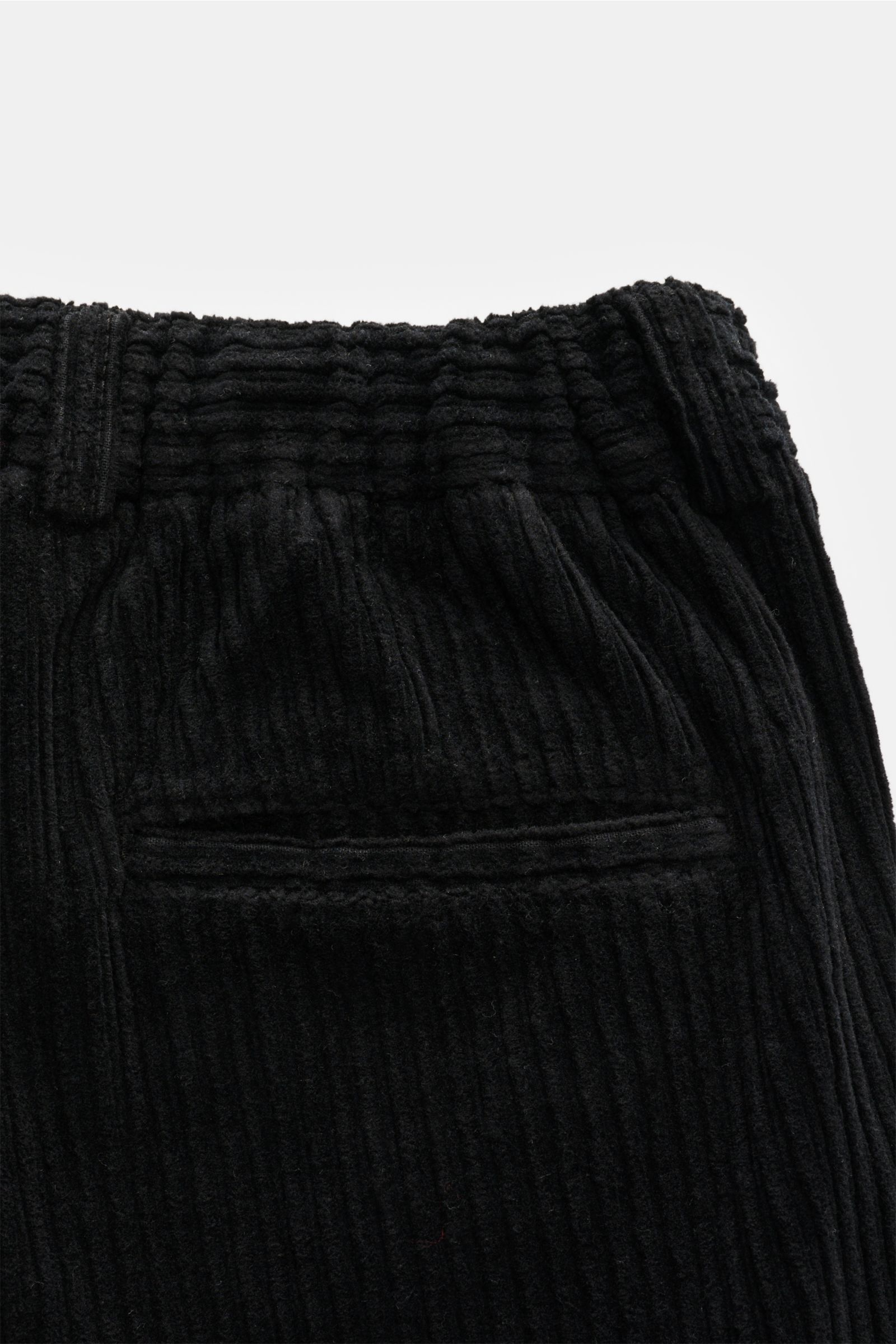 Close-up rear view of 04651/ A trip in a bag Corduroy cargo pants black, featuring wide wale cotton corduroy, slight stretch, soft feel, tapered fit, regular thigh width, ankle length, zip and waist button, partially elasticated waistband with drawstring,