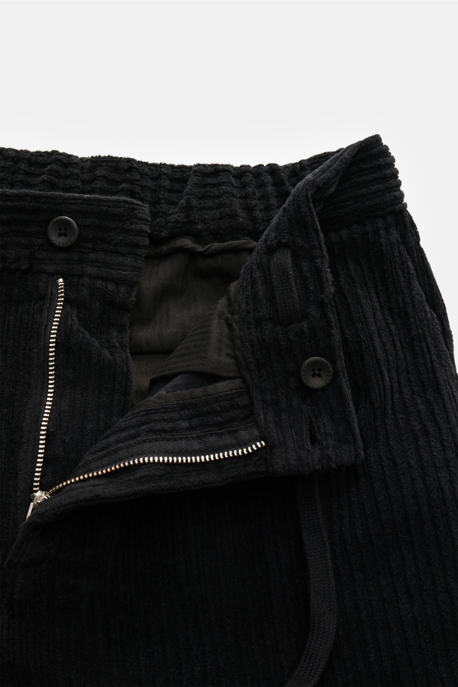 Close-up front view of 04651/ A trip in a bag Corduroy cargo pants black showing wide wale cotton corduroy, slight stretch, soft feel, tapered fit, regular thigh width, ankle length, zip and waist button, partially elasticated waistband with drawstring, F