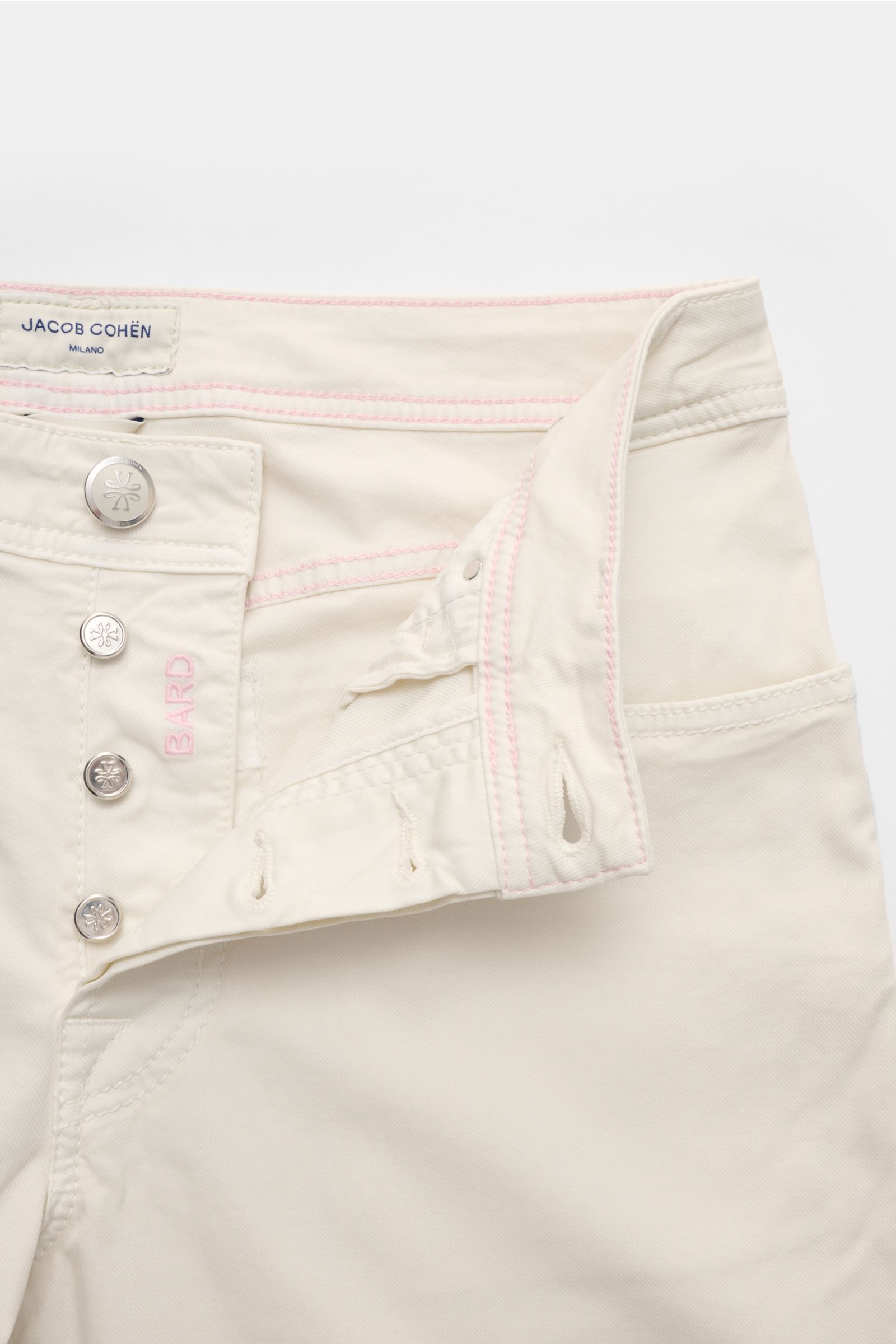 Close-up front view of Jacob Cohen Trousers 'Bard' off-white with button fly, pink tonal stitching, and cotton twill fabric.

Description: 
Get style and quality with the classic five-pocket trousers 'Bard' by JACOB COHEN in a slim fit. This luxurious 