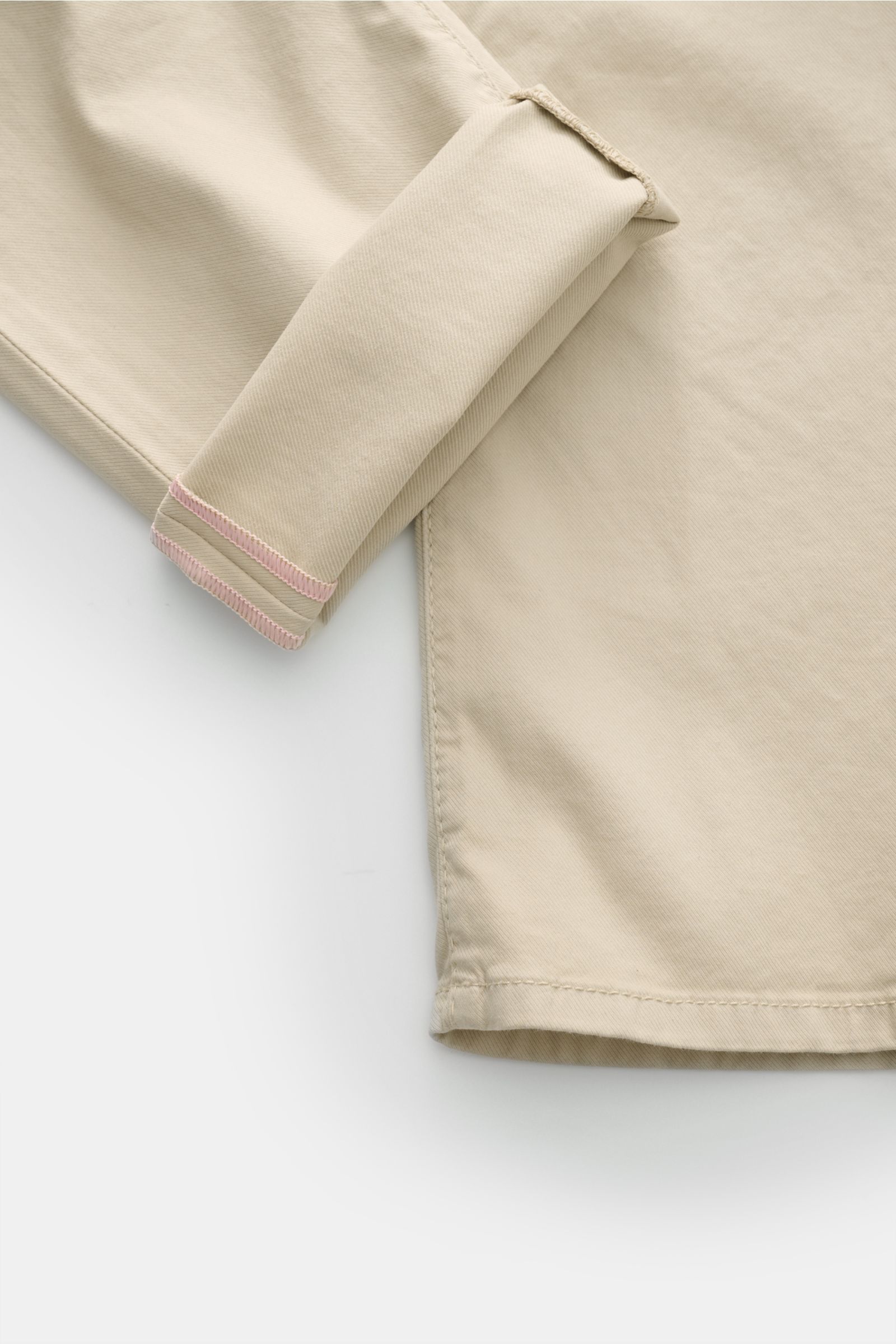 Jacob Cohen Hose 'Bard' beige, Detailfoto der beigen Baumwollhose im Slim Fit, Twill, Five-Pocket-Stil mit tonalem Stitching, Button Fly, Münztasche mit Initial und tonalem Leather Patch, Ansicht vom Hosenbein mit umgeschlagenem Saum.