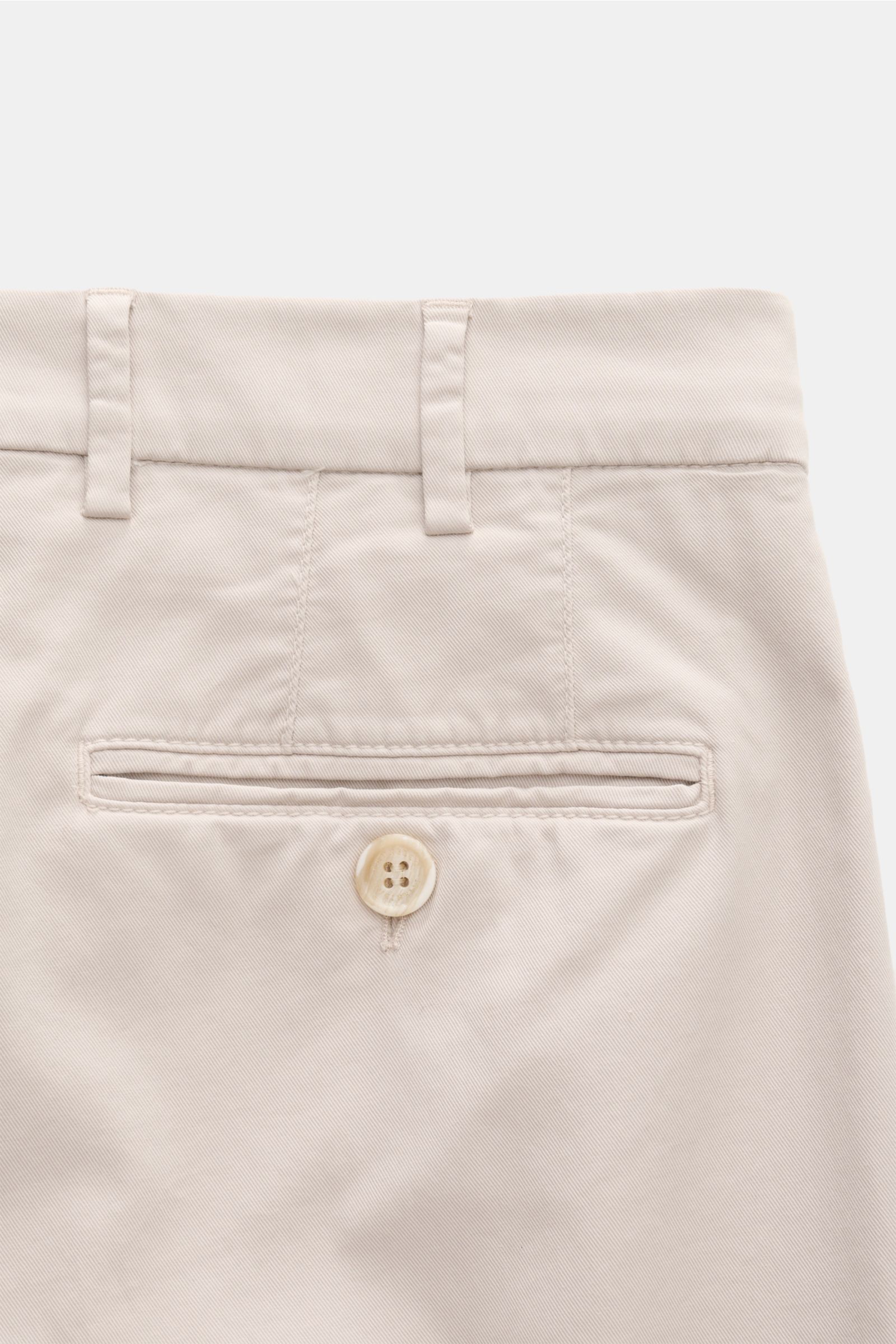 Brunello Cucinelli Chino 'Italian Fit' beige shown from a close-up rear view, highlighting garment-dyed twill cotton with fine texture, soft feel, regular fit, tapered short cut, buttoned welt back pocket, belt loops, and precise Italian craftsmanship. Di