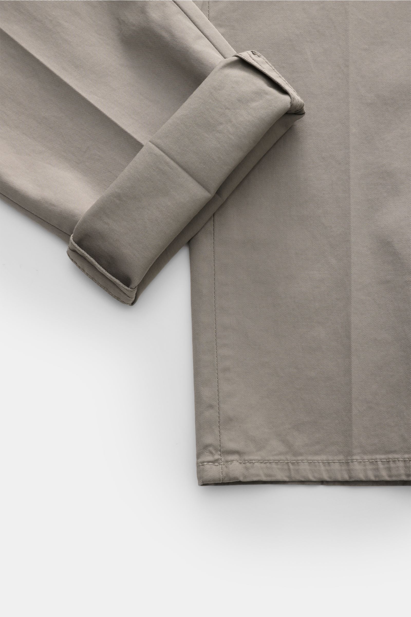 Close-up top-down view of the folded cuff and hem of Brunello Cucinelli Chino 'Italian Fit' grau, made of elastic cotton twill with fine texture.