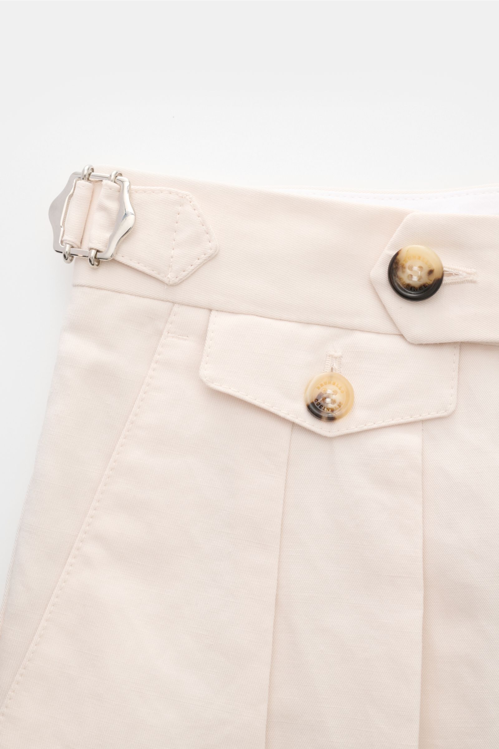 Brunello Cucinelli Hose creme aus Baumwoll-Leinen-Twill, schmal zulaufend, mit Bundhaken, Side Adjuster, doppelter Bundfalte, Knopfverschluss, fotografiert aus Nahaufnahme von oben.