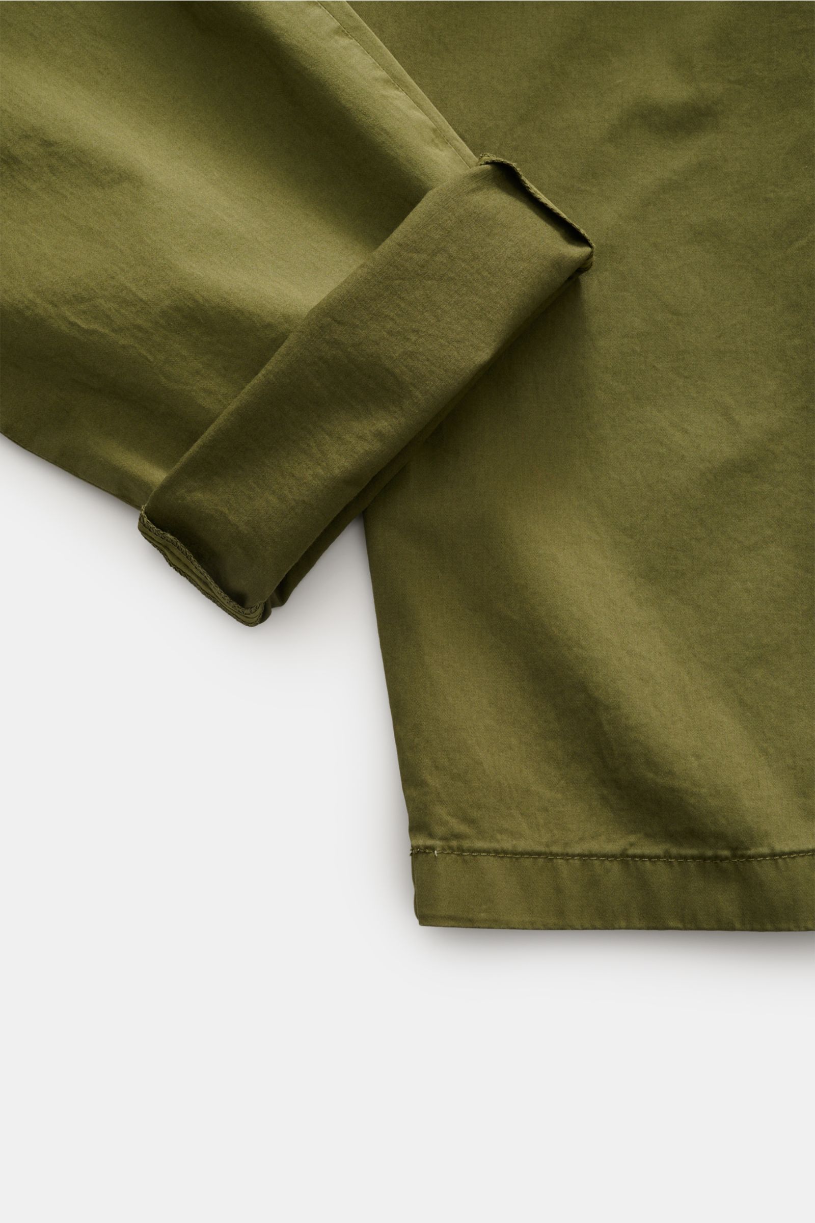 Nahaufnahme der olivgrünen Closed Baumwollhose 'Bergen Tapered' im Tapered Fit, Detailansicht des umgeschlagenen Hosenbeins aus leicht elastischem Baumwollsatin.