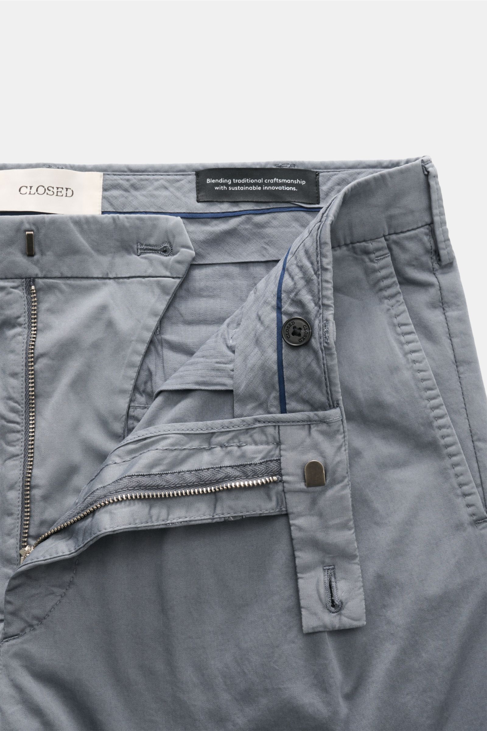 Closed Baumwollhose 'Bergen Tapered' rauchblau, Nahaufnahme von innen mit geöffnetem Reißverschluss, Bundhaken, doppelter Bundfalte, paspelierten Taschen.