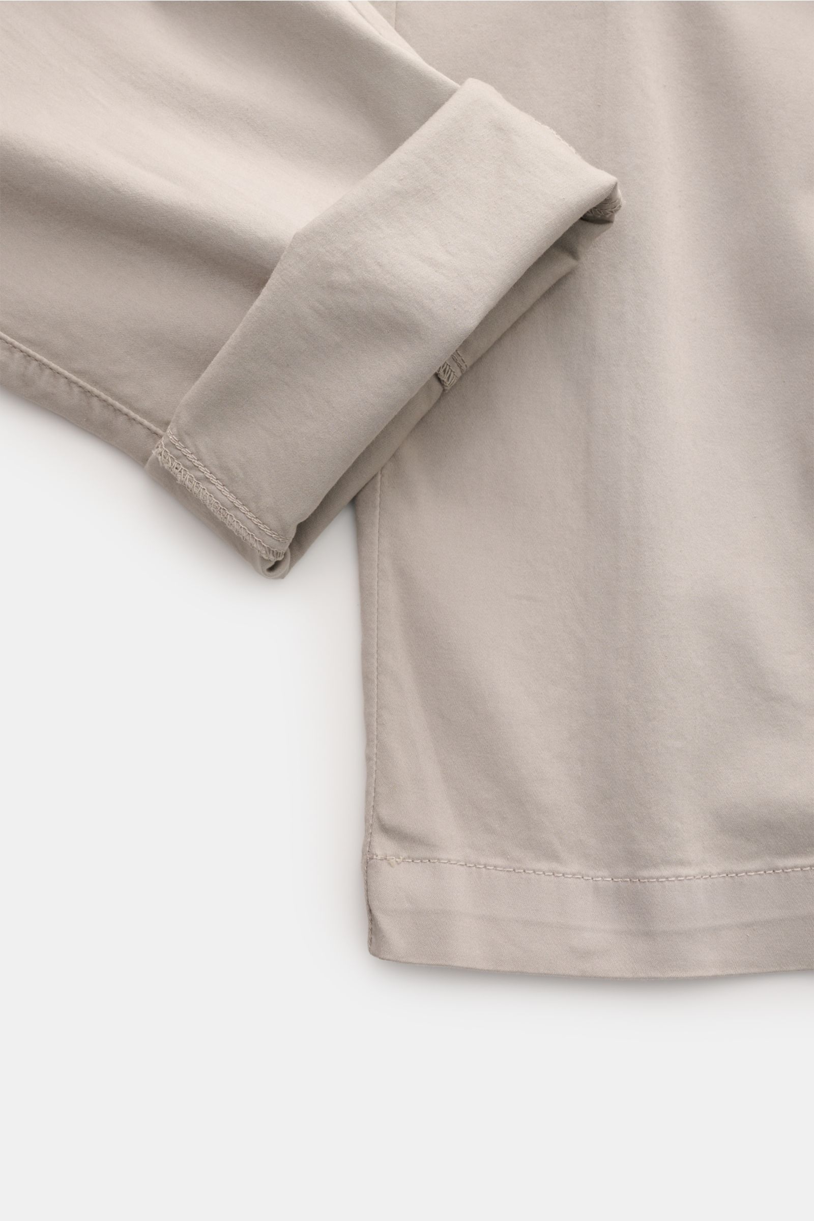 Close-up of the lower leg and cuff of the C.P. Company Cargohose hellgrau, showcasing soft, light grey cotton gabardine fabric with a comfortable stretch and regular fit, photographed from a side angle. Urban Utility: Die Cargohose von C.P. COMPANY kombin