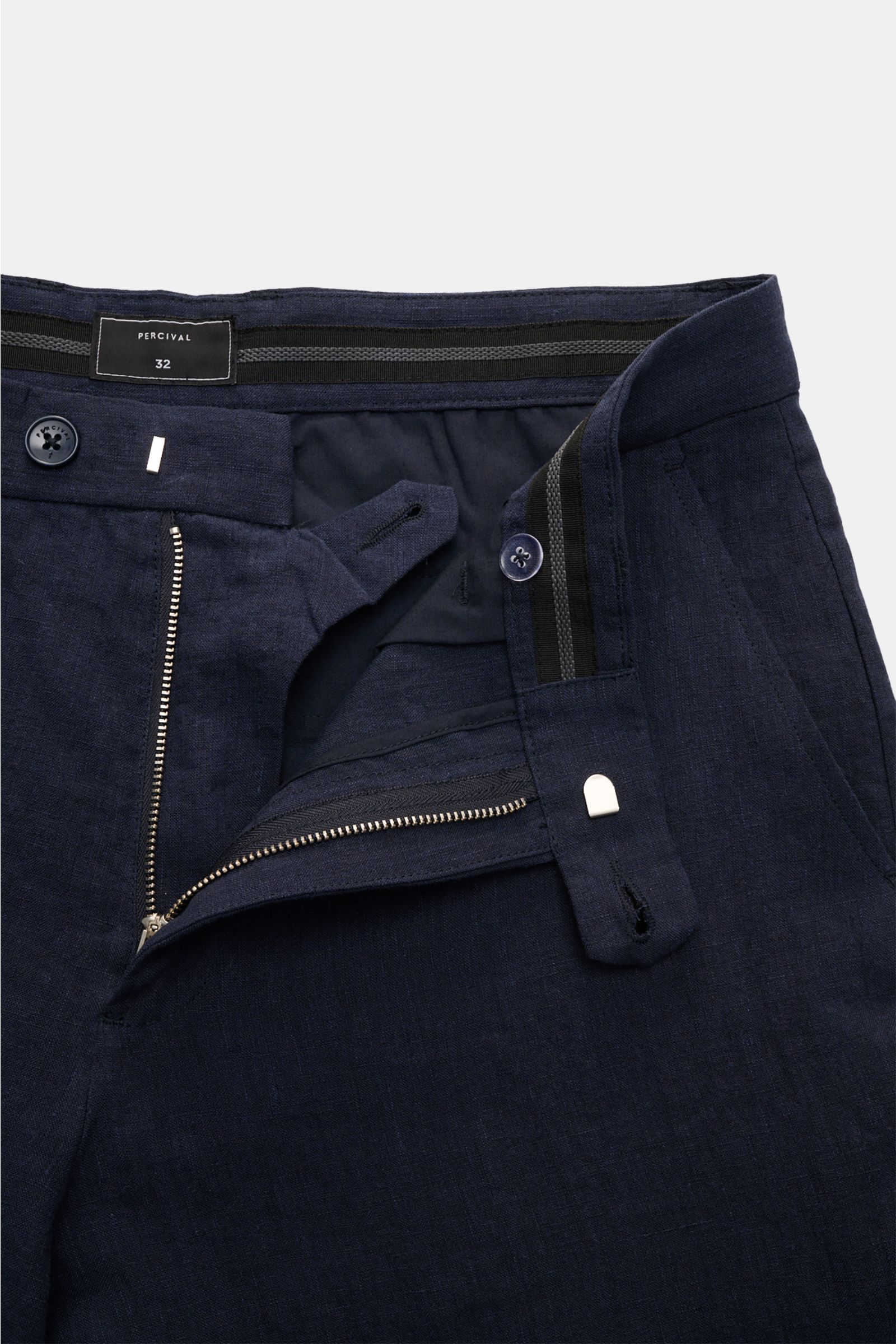 Close-up front view of Percival Linen trousers 'Tailored Linen' navy showing waistband, button, zip, and textured lightweight linen fabric. Combines texture and everyday suitability: These summery trousers by PERCIVAL are made of breathable, lightweight l