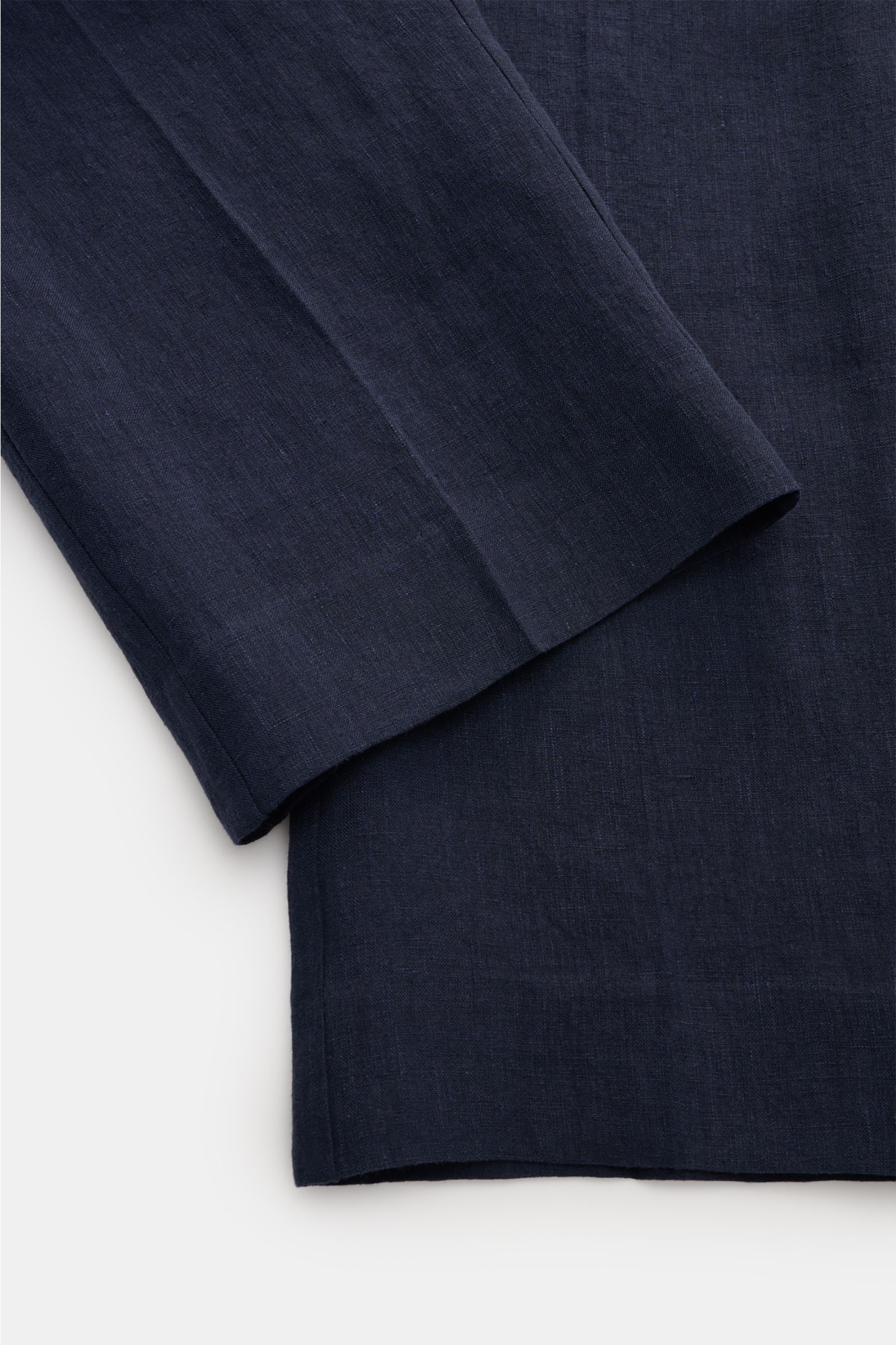 Close-up photo of the lower legs of Percival Linen trousers 'Tailored Linen' navy, showing the ankle-length tapered fit and linen texture from a top-down perspective. Combines texture and everyday suitability: These summery trousers by PERCIVAL are made o