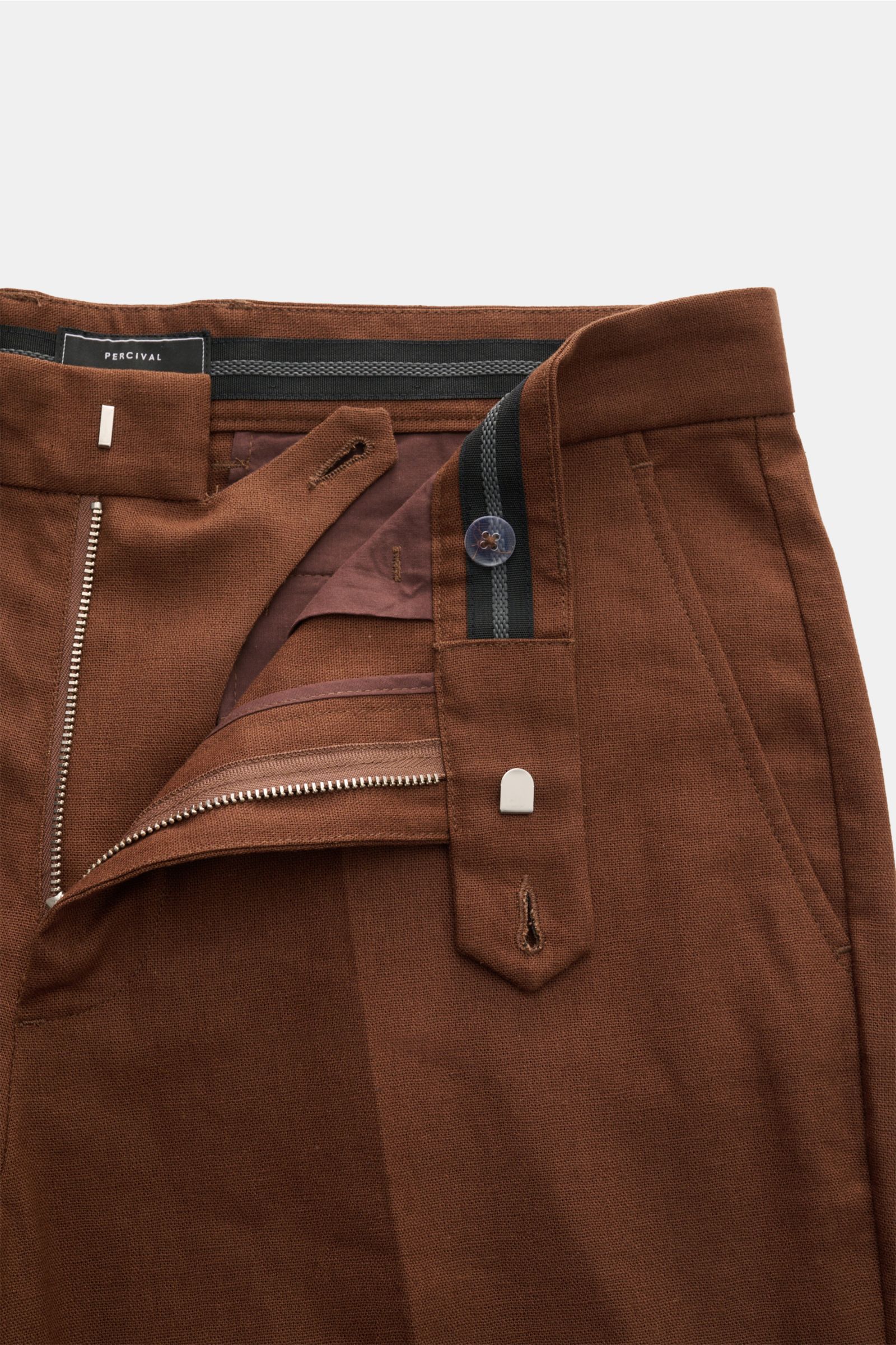 Close-up front view of Percival Trousers 'Tailored Linen' brown, showing zip, waist button, and signature linen-cotton texture.

Stay smart this summer: The straight cut trousers 'Tailored Linen' made of linen and cotton by London label PERCIVAL are ma