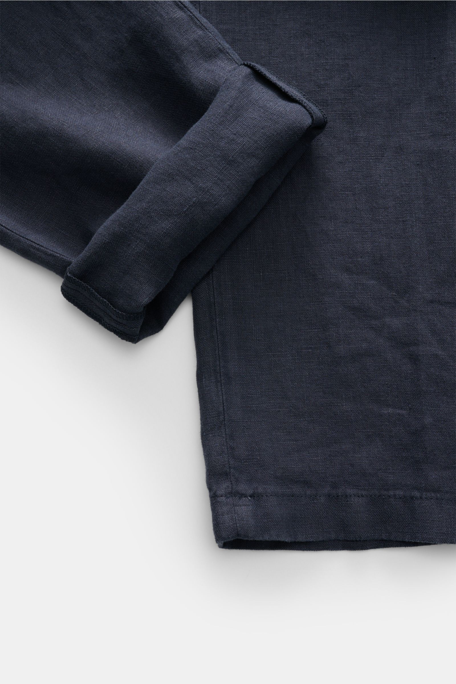 Nahaufnahme der geschlossenen Closed Leinen-Jogpants navy aus reiner Leinenqualität mit leicht griffiger Struktur, schmal zulaufendem Bein und kurzem Schnitt, fotografiert von oben.