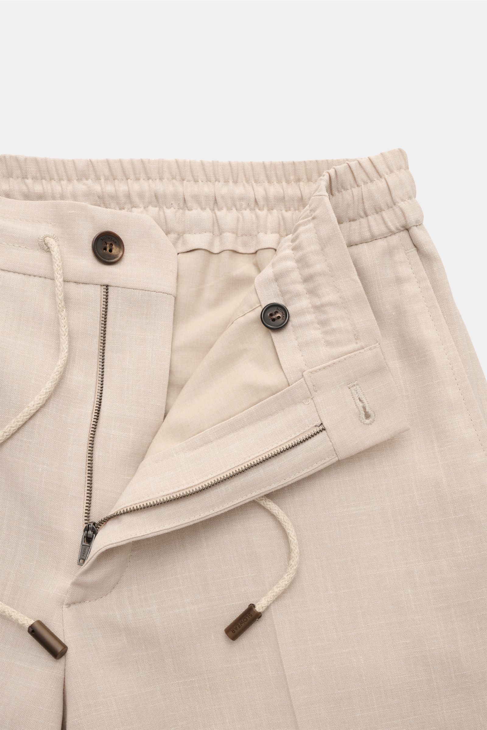 Close-up front view of Incotex Jogger pants sand showing elasticated waistband with drawstring, zip, button, and pocket details, made from a wool, silk, and linen blend with a smooth feel and slightly tapered regular fit. 