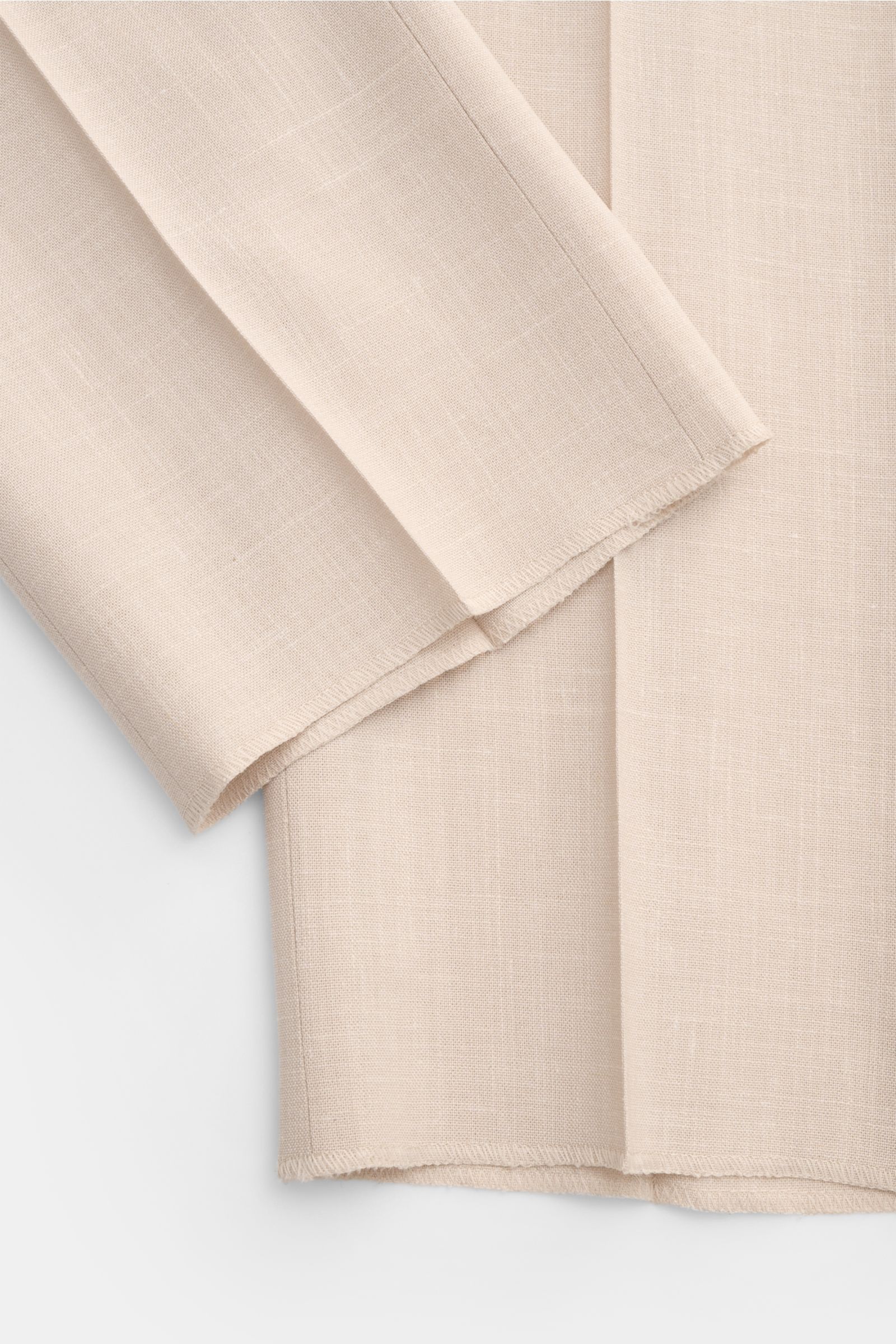 Incotex Jogger pants sand shown in close-up from a top-down perspective, highlighting fine wool, silk, linen blend fabric with smooth texture and detailed stitching. INCOTEX are unquestionably the experts in tailoring when it comes to high-quality trouser