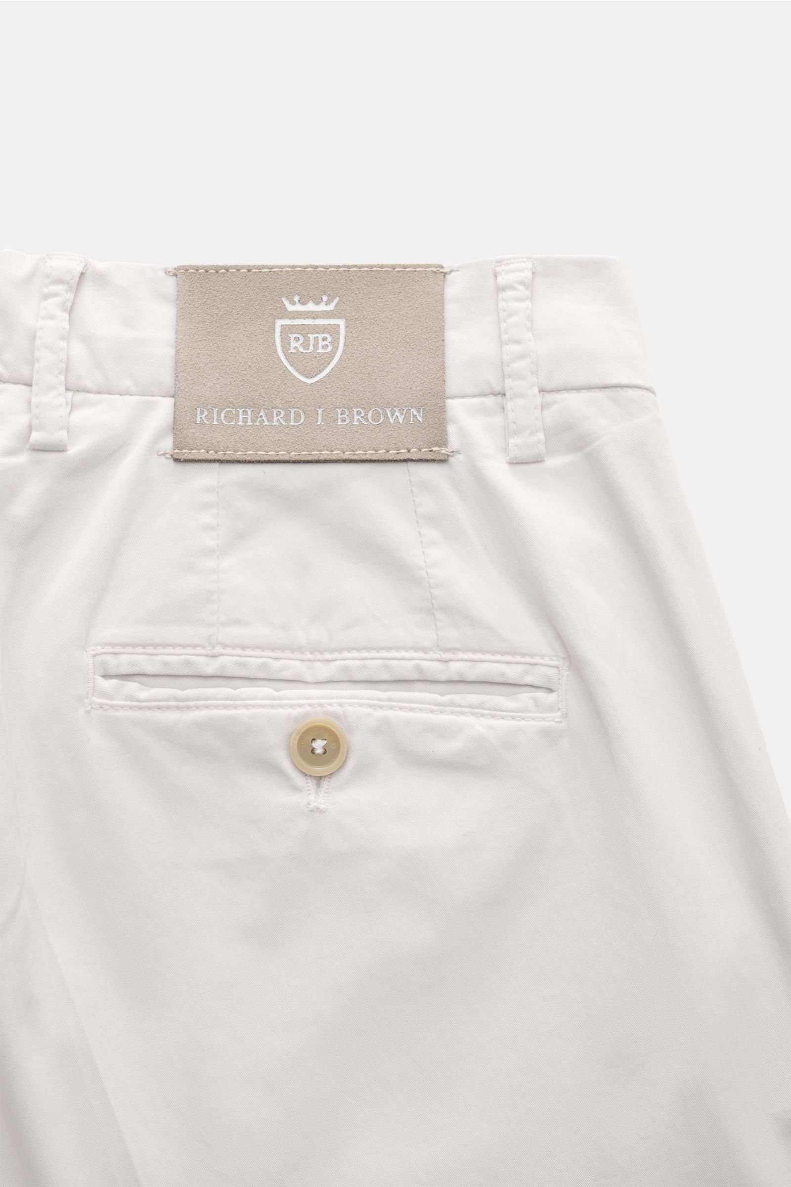 Rear close-up of Richard J. Brown Chinos 'Singapore' sand showing back pocket with button and leather brand patch. Everyday luxury: Soft cotton with slight stretch content give the model 'Singapore' by RICHARD J. BROWN a soft feel and maximum comfort. Cot