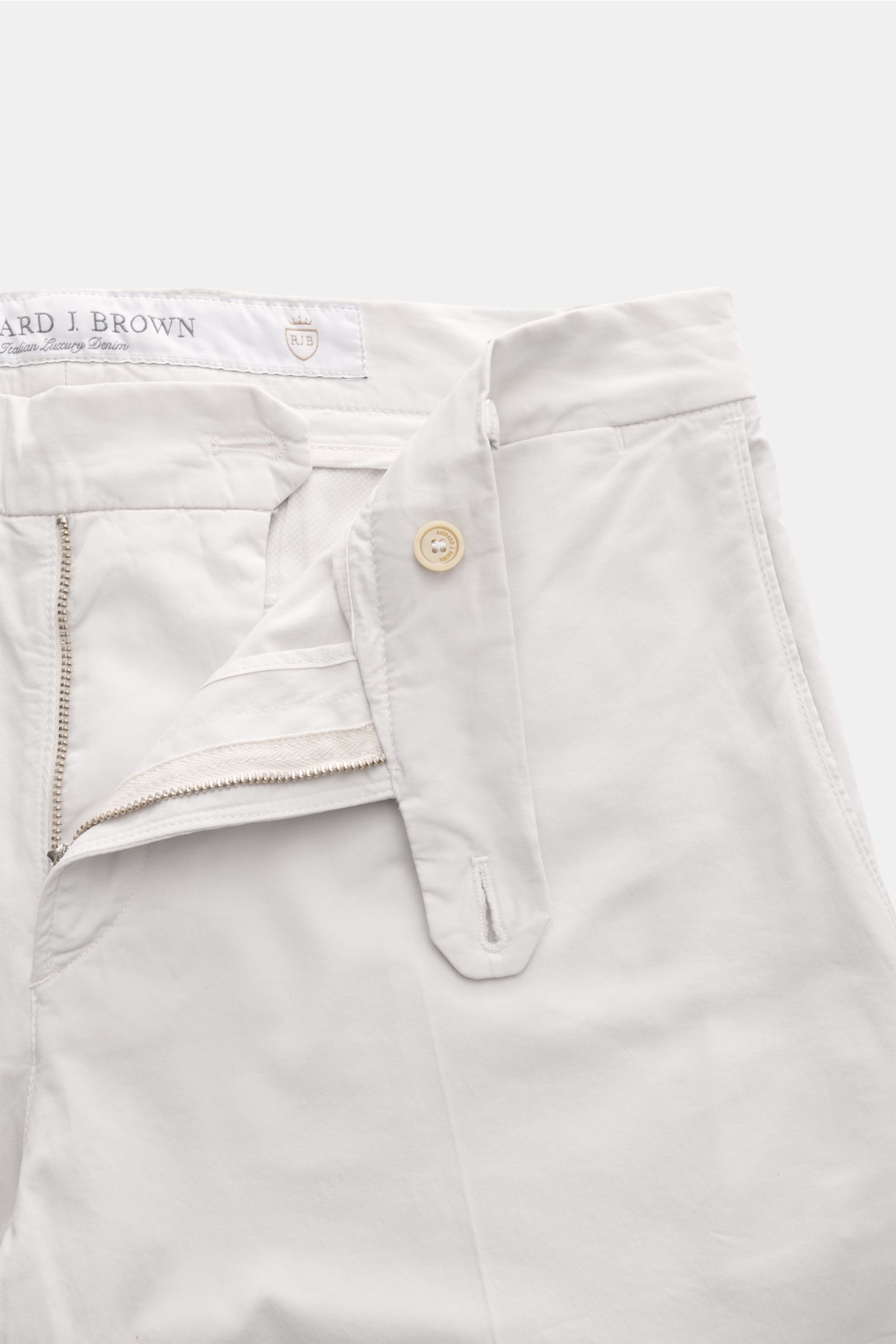 Close-up front view of Richard J. Brown Chinos 'Singapore' sand showing zip, waist buttons, extended buttoned tab, and fine twill texture. Everyday luxury: Soft cotton with slight stretch content give the model 'Singapore' by RICHARD J. BROWN a soft feel 
