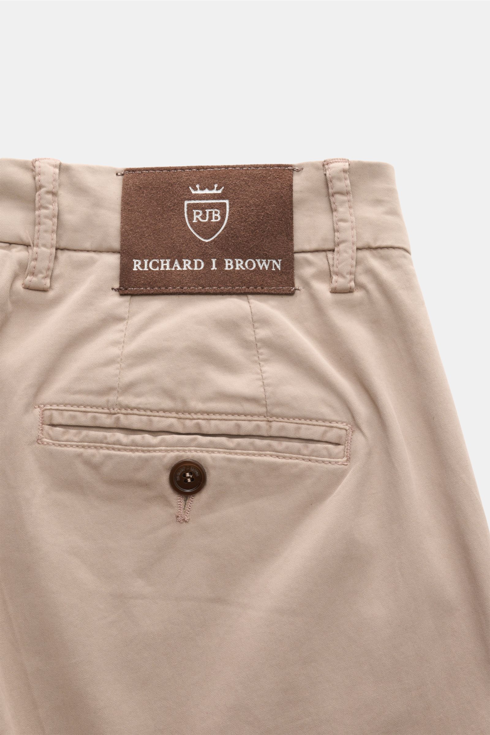 Rear close-up of Richard J. Brown Chinos 'Singapore' beige, showing back pocket with button and leather brand patch. Everyday luxury: Soft cotton with slight stretch content give the model 'Singapore' by RICHARD J. BROWN a soft feel and maximum comfort. C