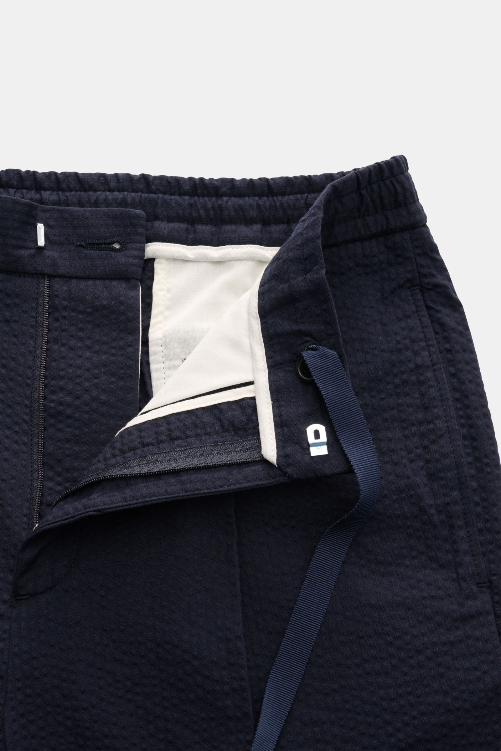 Officine Générale Jogpants 'Drew' navy, Detailansicht von oben, Baumwoll-Seersucker, Tapered Fit, Reißverschluss, Bundhaken, elastischer Bund, Taschen.