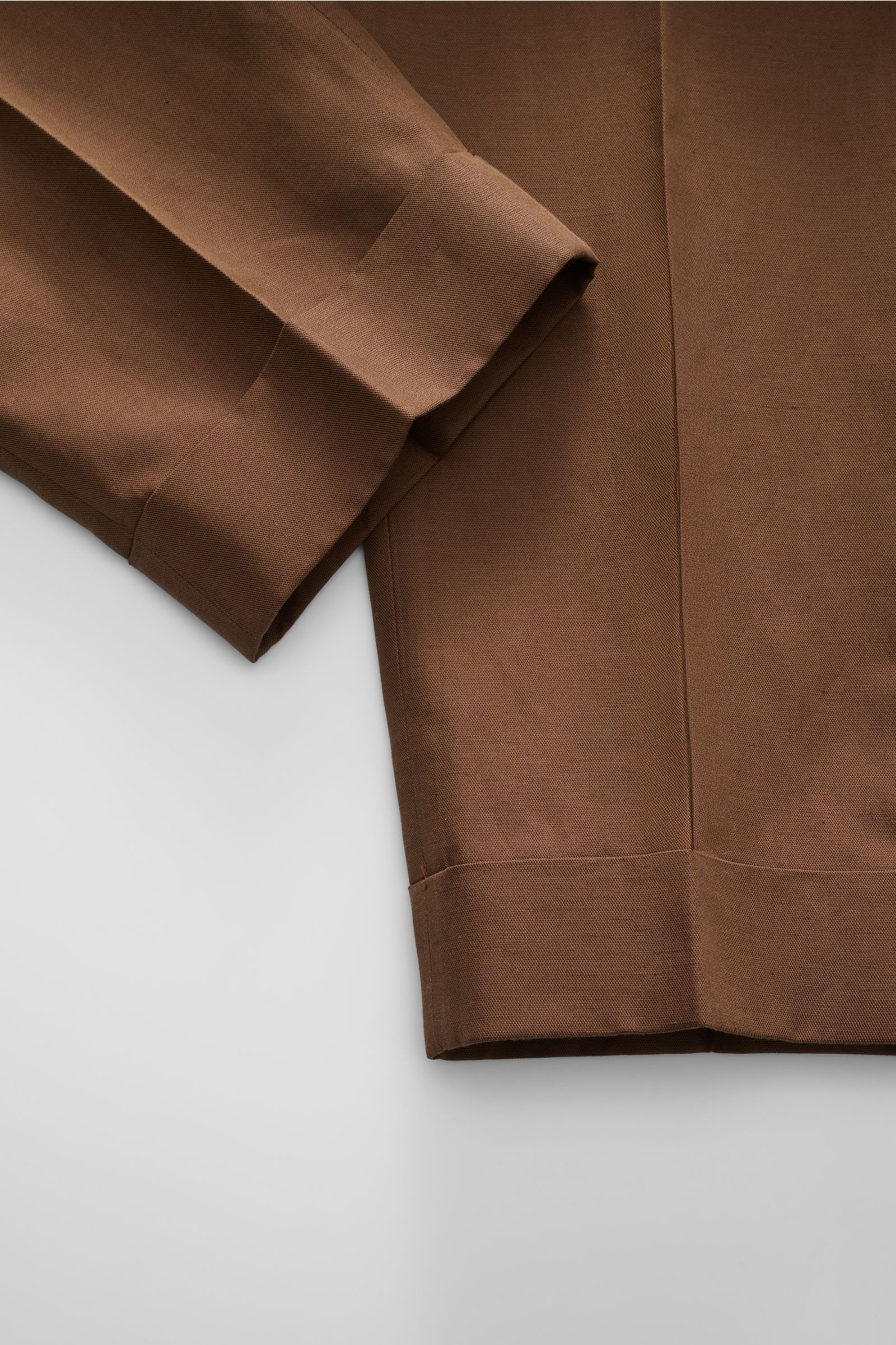 Nahaufnahme der braunen Officine Générale Hose 'Hugo' in Tapered Fit, schmal zulaufend mit fixiertem Saumaufschlag, aus Lyocell, Leinen, Baumwolle.