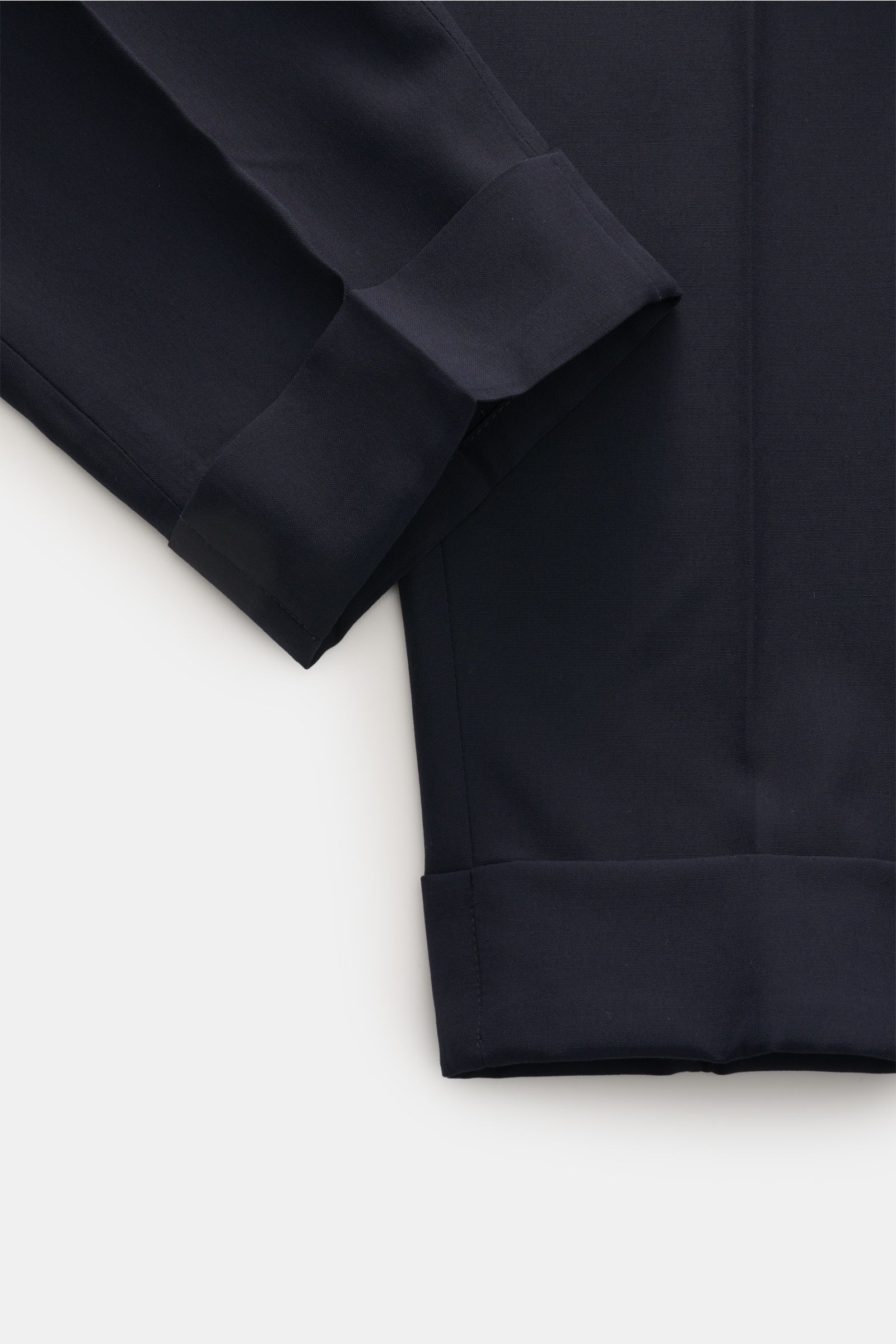 PT Torino Wool trousers 'Carrot Fit' navy shown from a close-up top view focusing on the cuff and fabric texture. Classic elegance with a modern twist: With their short cut, stylish pleats and extended buttoned tab, the trousers 'Carrot Fit' by PT TORINO 