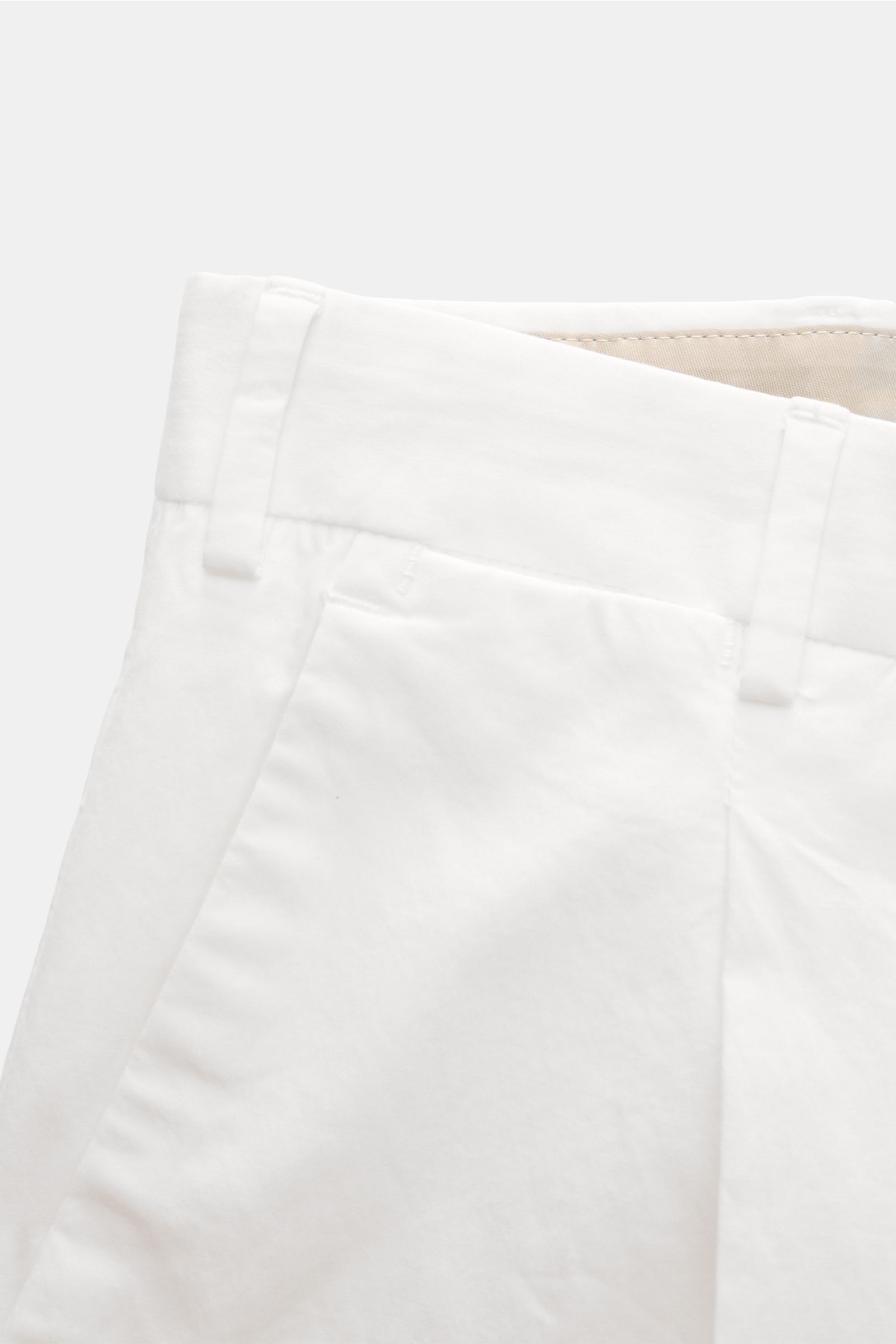 Close-up front view of PT Torino Chinos 'Rebel Fit' white, tapered fit cotton chinos with zip and hook fastener, French pockets, single pleat, back pockets with flap and button, small metal initial, and fixed hem turn-up. You can’t go wrong with PT TORINO
