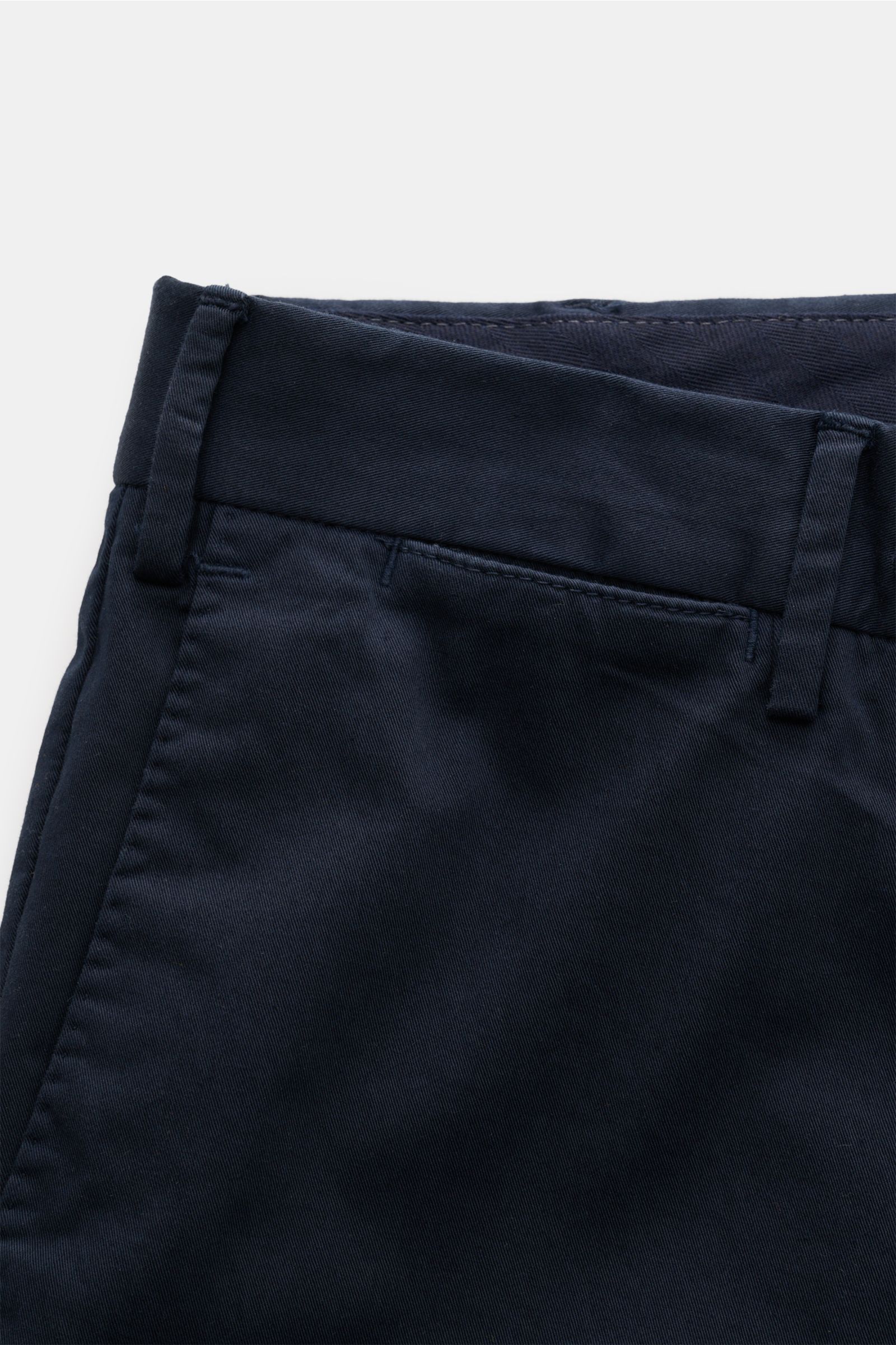 Nahaufnahme der Taille der PT Torino Chino 'Slim Fit' navy aus Baumwolltwill mit leichtem Stretch, schmal zulaufend, Reißverschluss, Bundknöpfen, französischen Taschen, kleiner Uhrentasche und paspelierten Gesäßtaschen mit Knopf, fotografiert von schräg o