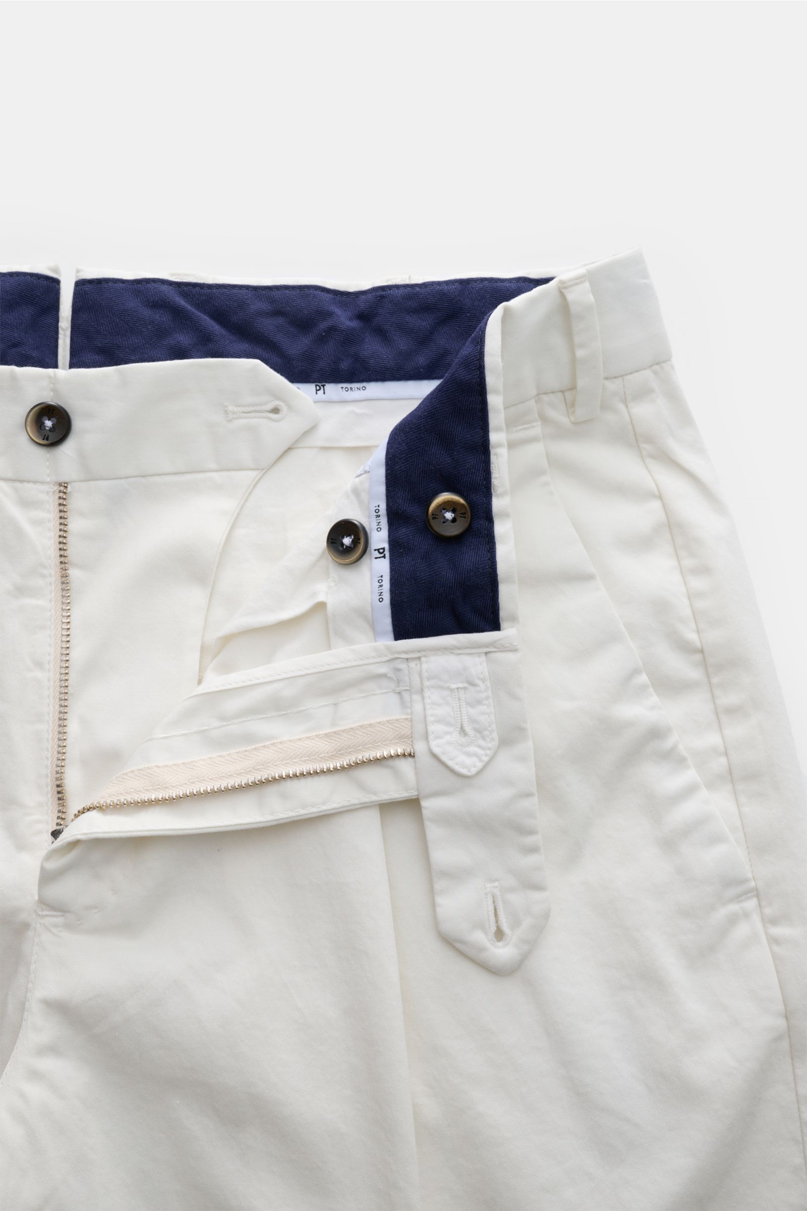 PT Torino Chino 'Union Fit' creme aus Baumwolltwill mit leichtem Stretch, schmal zulaufend, einfache Bundfalte, Reißverschluss, Knöpfen, fotografiert aus Nahaufnahme oben.