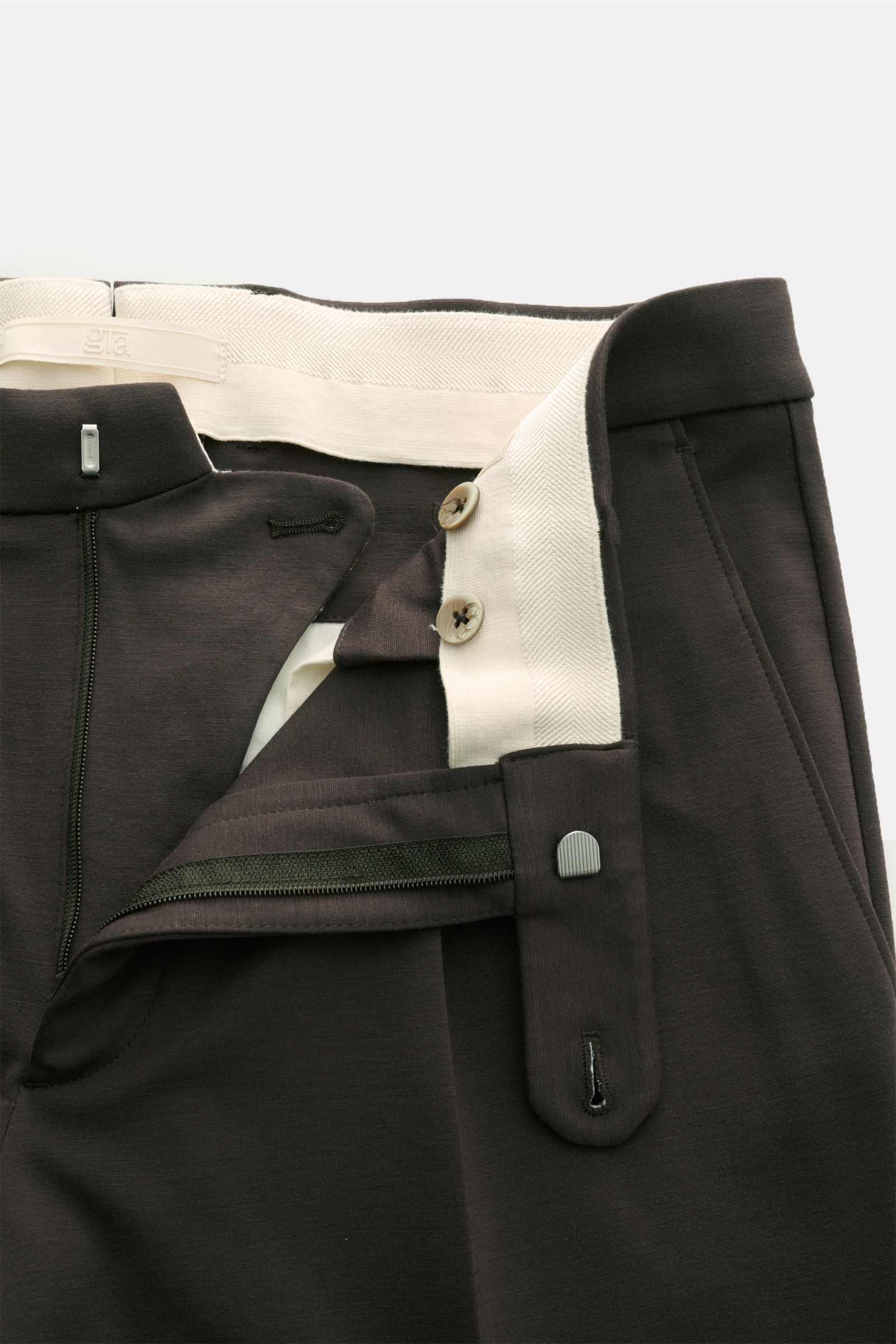 Close-up front view of GTA Jersey trousers 'Federico' dark brown with open zipper, button, and elastic waistband showing soft, elastic jersey fabric.

Description:  
For casual office looks: The jersey trousers 'Federico' by GTA combine maximum comfort