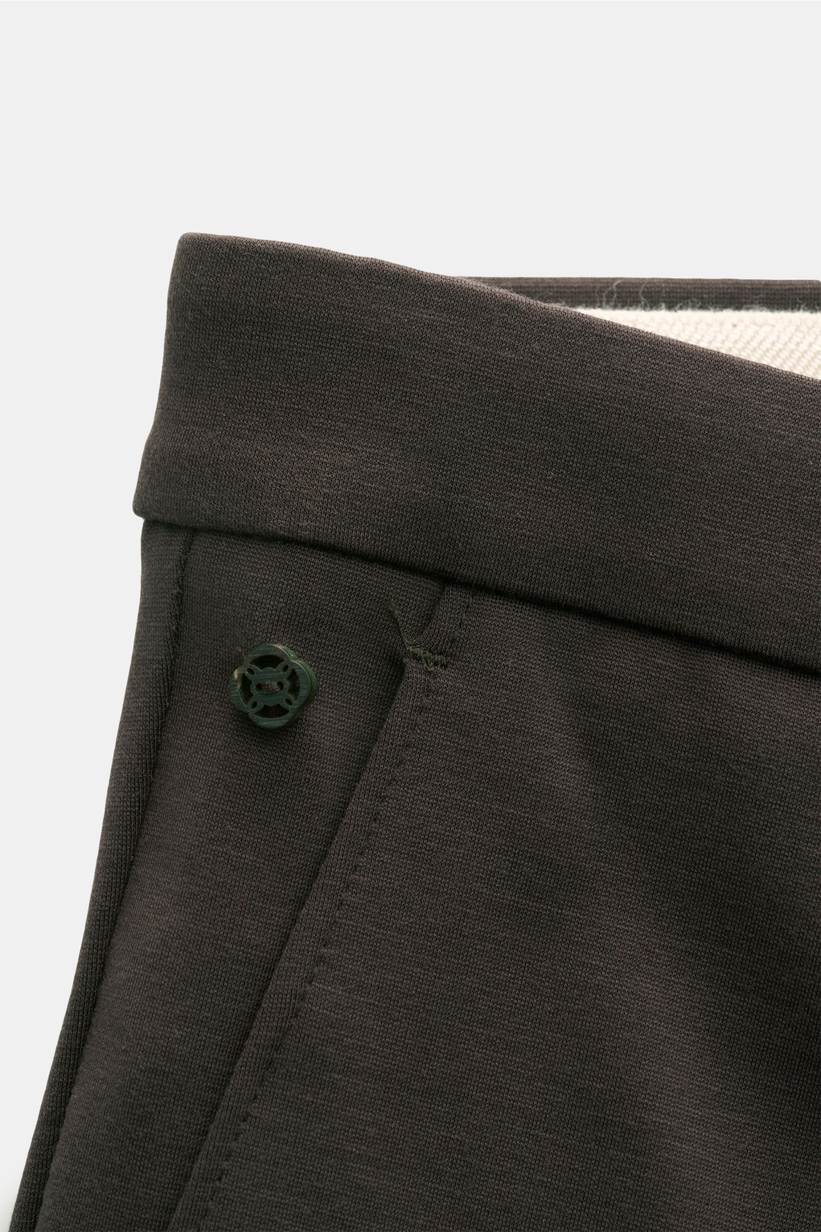 GTA Jersey trousers 'Federico' dark brown shown in a close-up angled view of the waistband, featuring elastic insert, zip, waist button, and soft jersey fabric made of viscose and microfiber. For casual office looks: The jersey trousers 'Federico' by GTA 